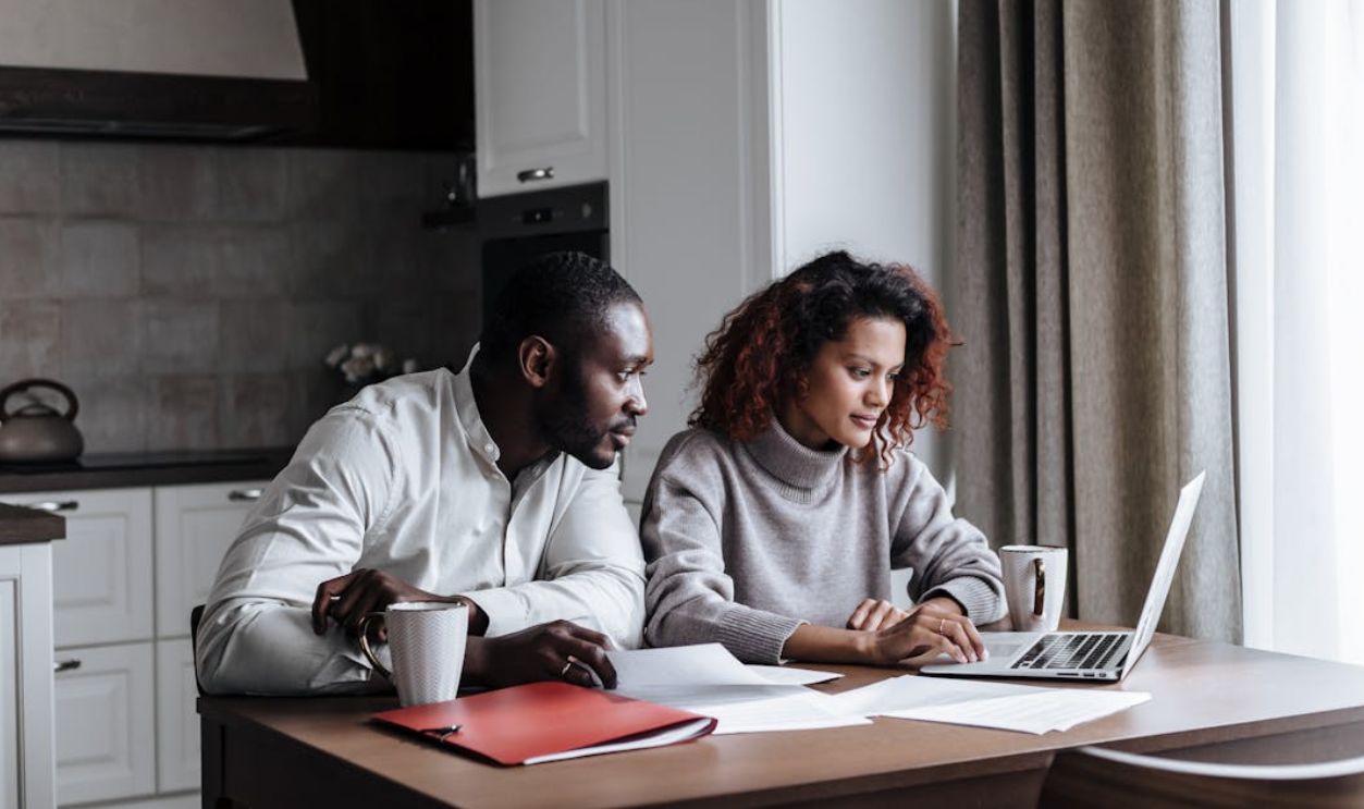 A Couple Working in Kitchen on a Laptop