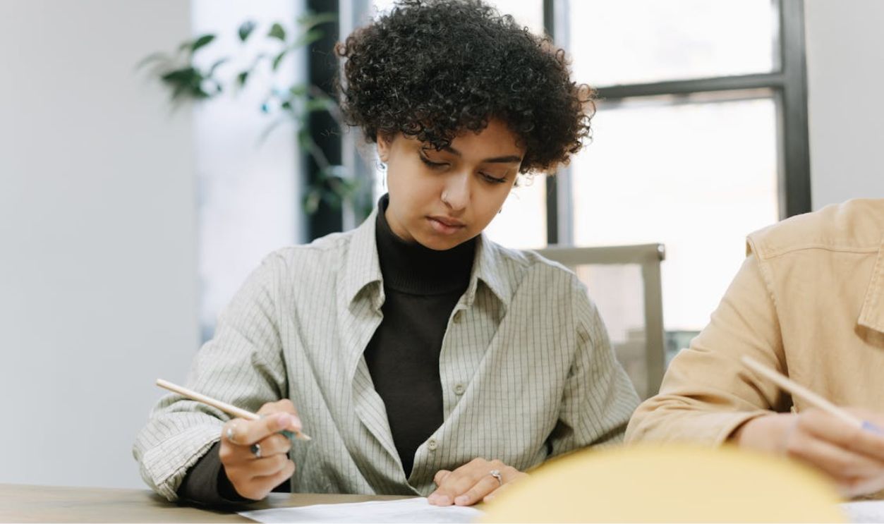 A Woman with Curly Hair while Writing