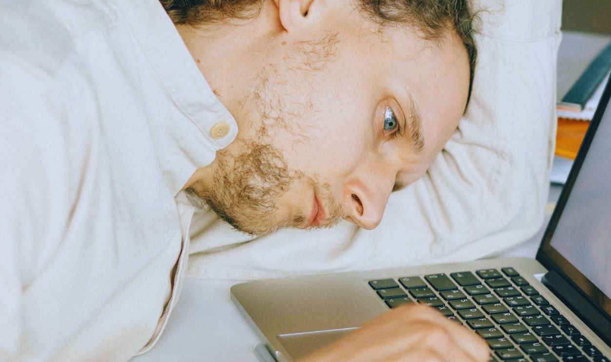 Overworked Employee lying in front of Laptop