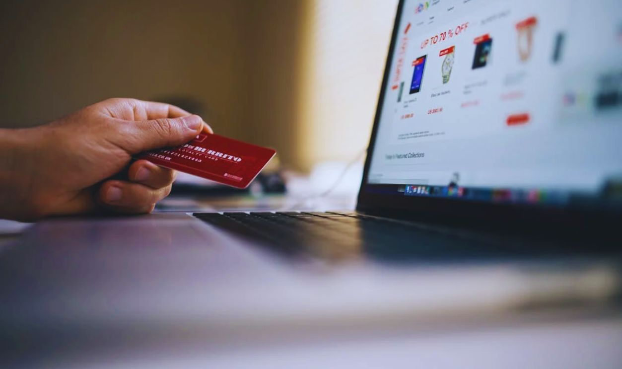 Black and Gray Laptop Computer With Turned-on Screen Beside Person Holding Red Smart Card in Selective-focus Photography