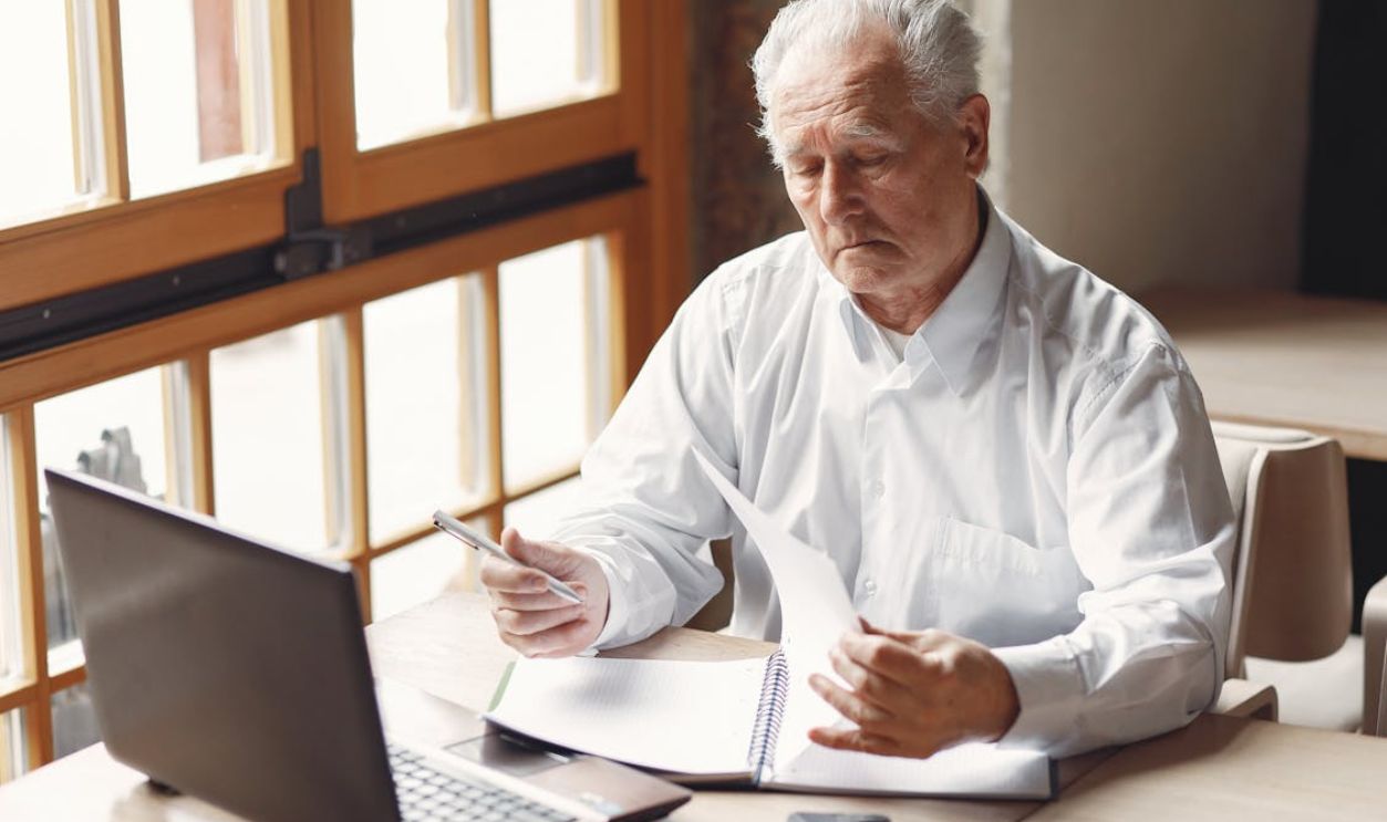 Concentrated senior businessman working remotely in modern office