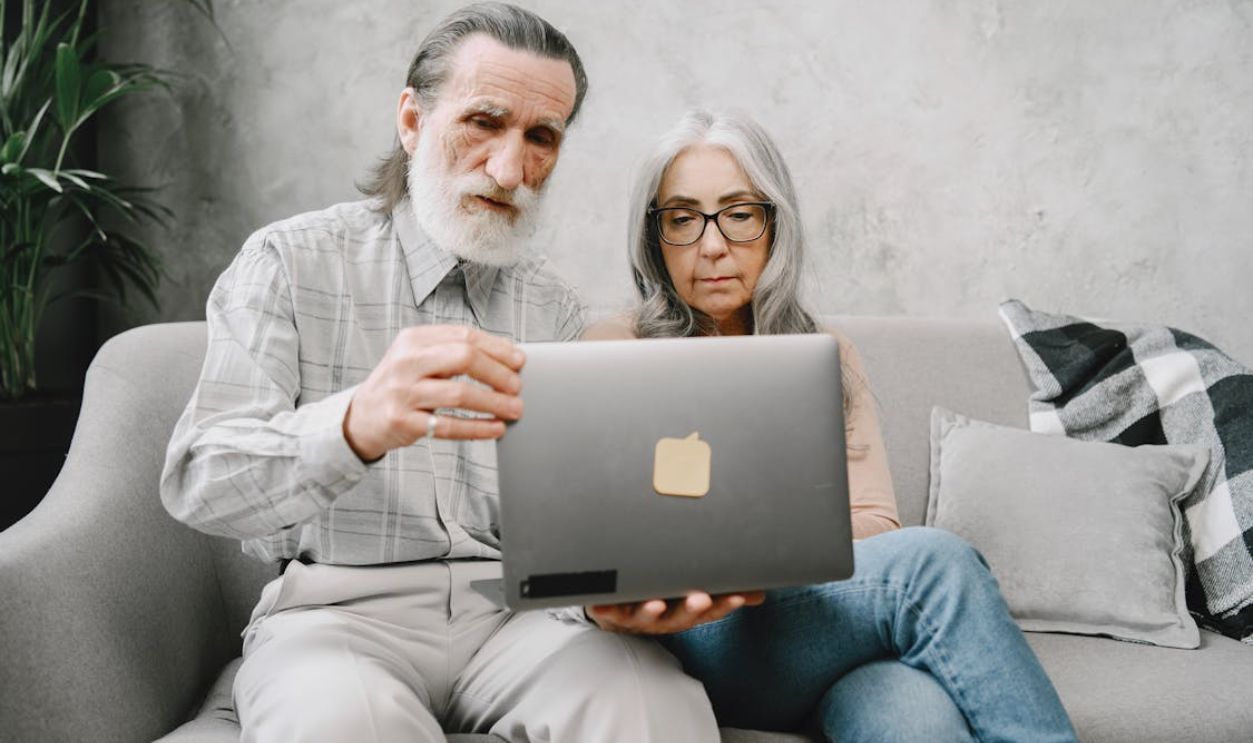 Elderly Couple looking at a Gray Laptop