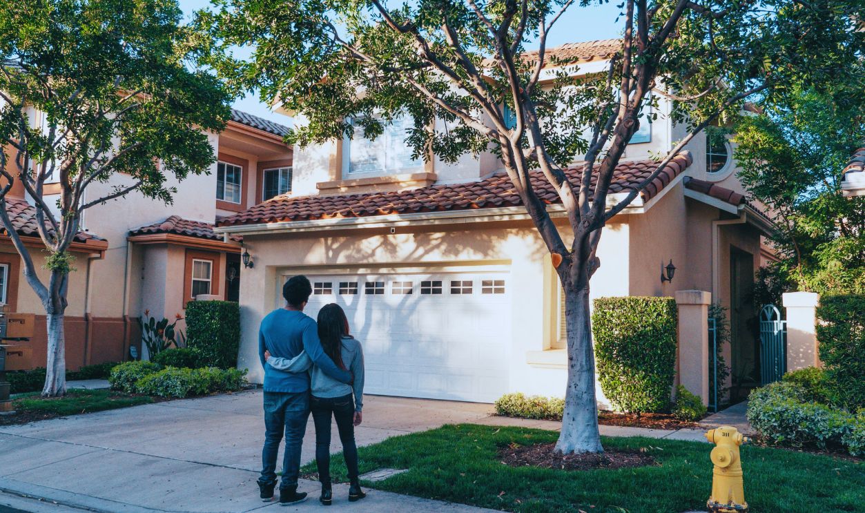 Couple Standing In Front of their House