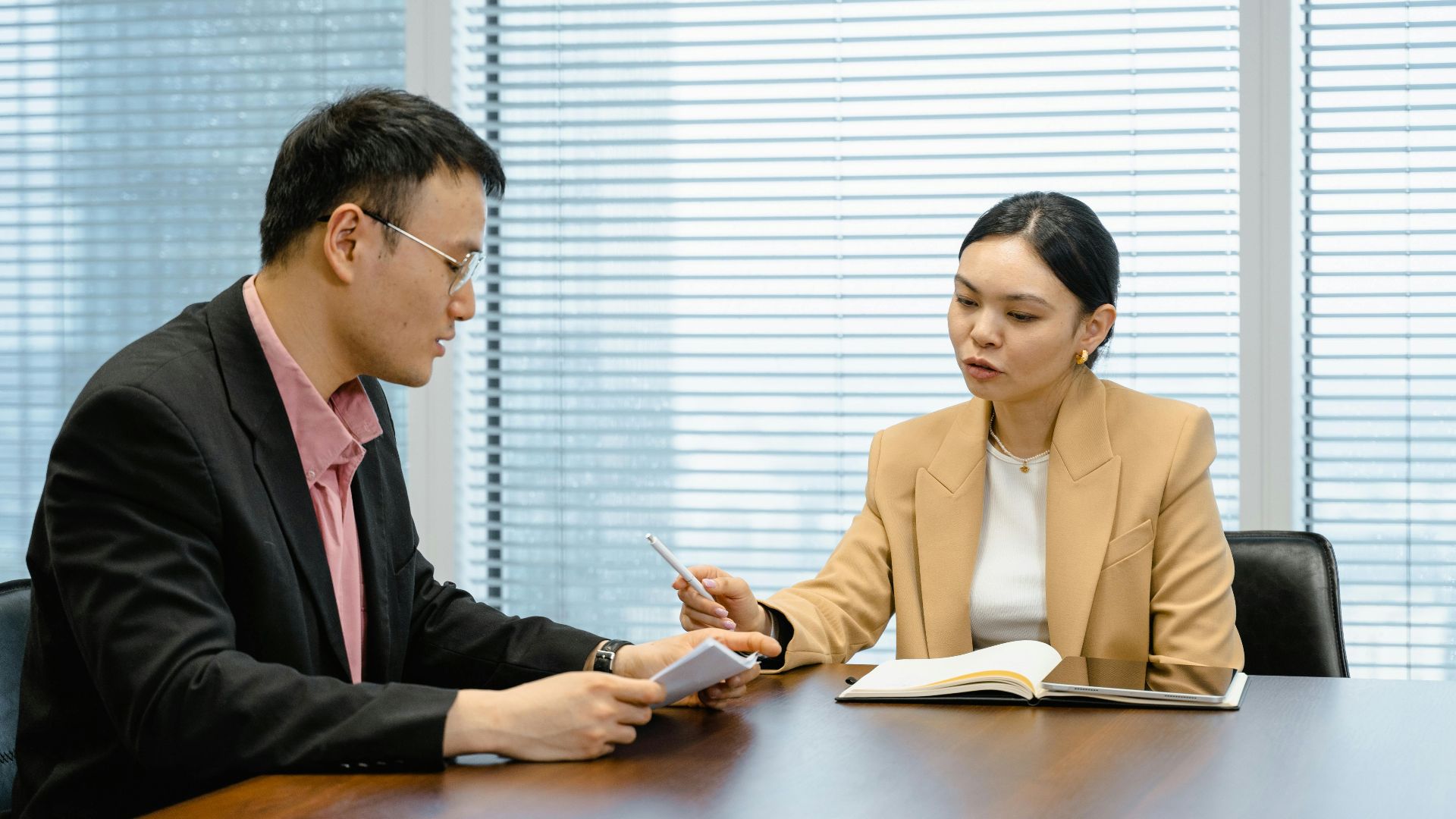 Two business professionals engaged in a collaborative meeting in a modern office setting.