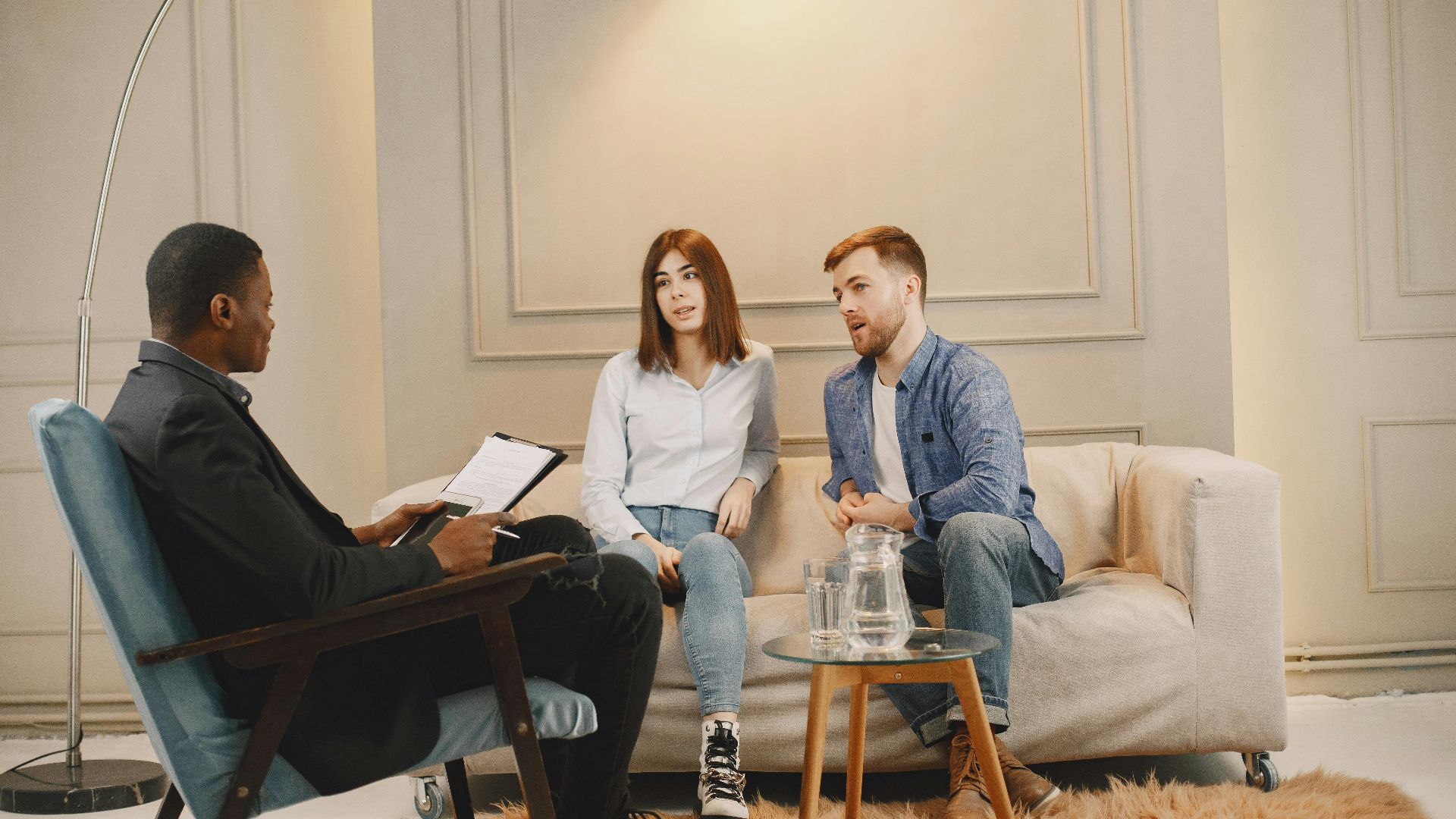 A realtor meeting with a couple to discuss real estate options. Modern indoor setting with a casual atmosphere.