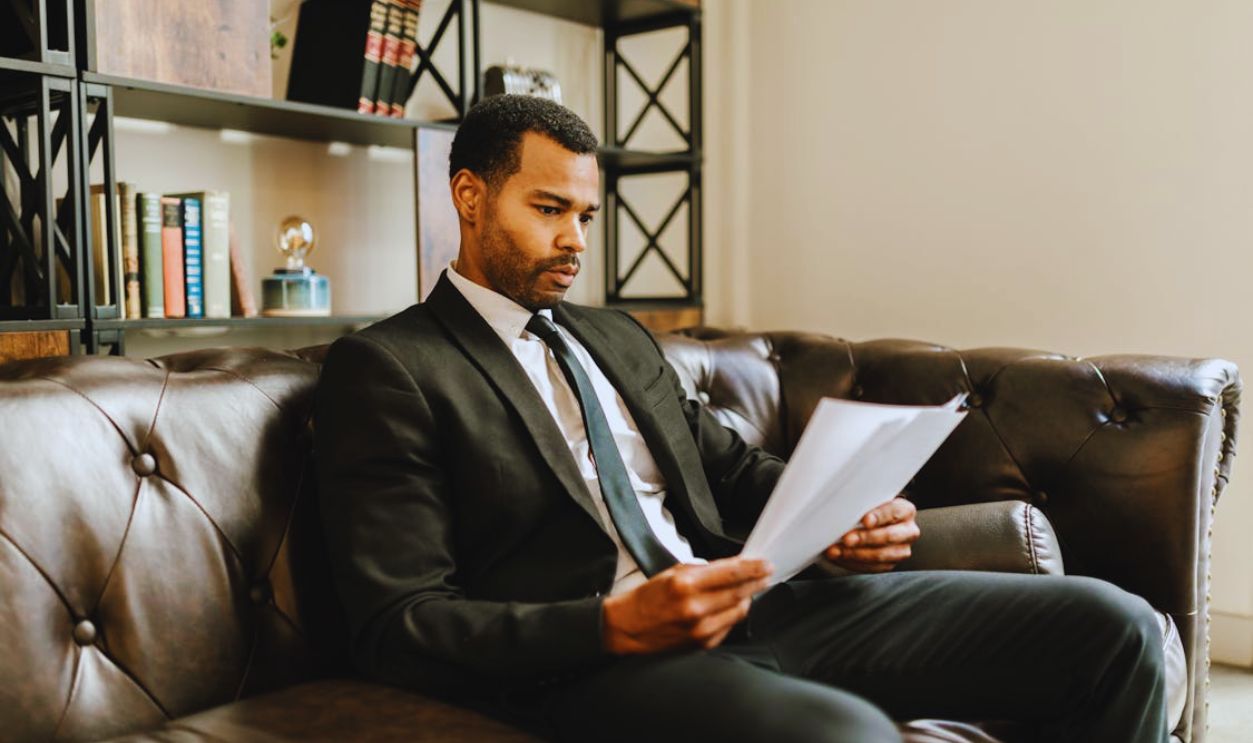 A Man in a Suit Looking at Documents