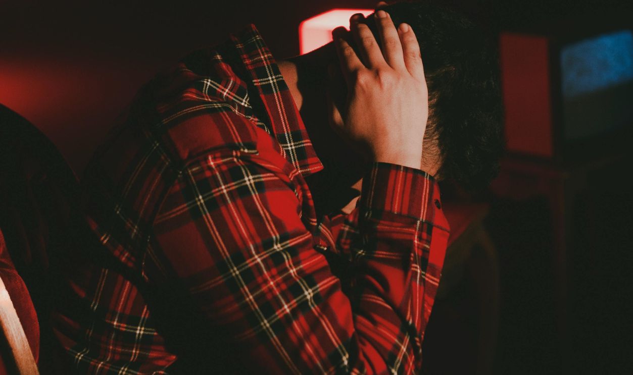 Man with hands behind head sitting in solitude