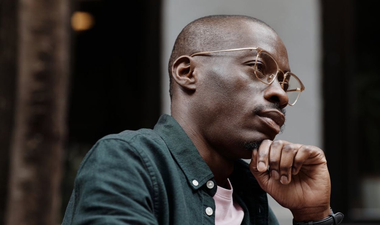 Close-up of a Man Wearing Eyeglasses and his Hand on his Chin