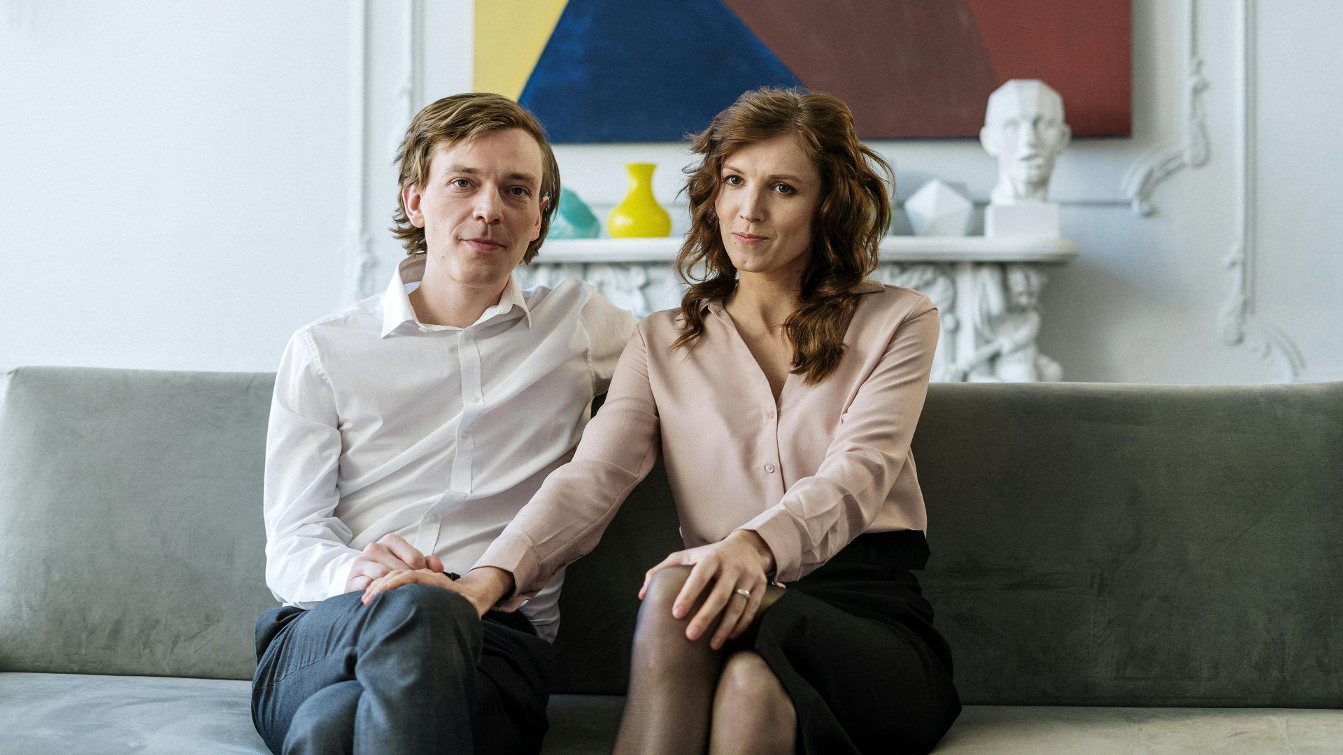 A couple sitting on a couch during a counseling session, showing connection and support.