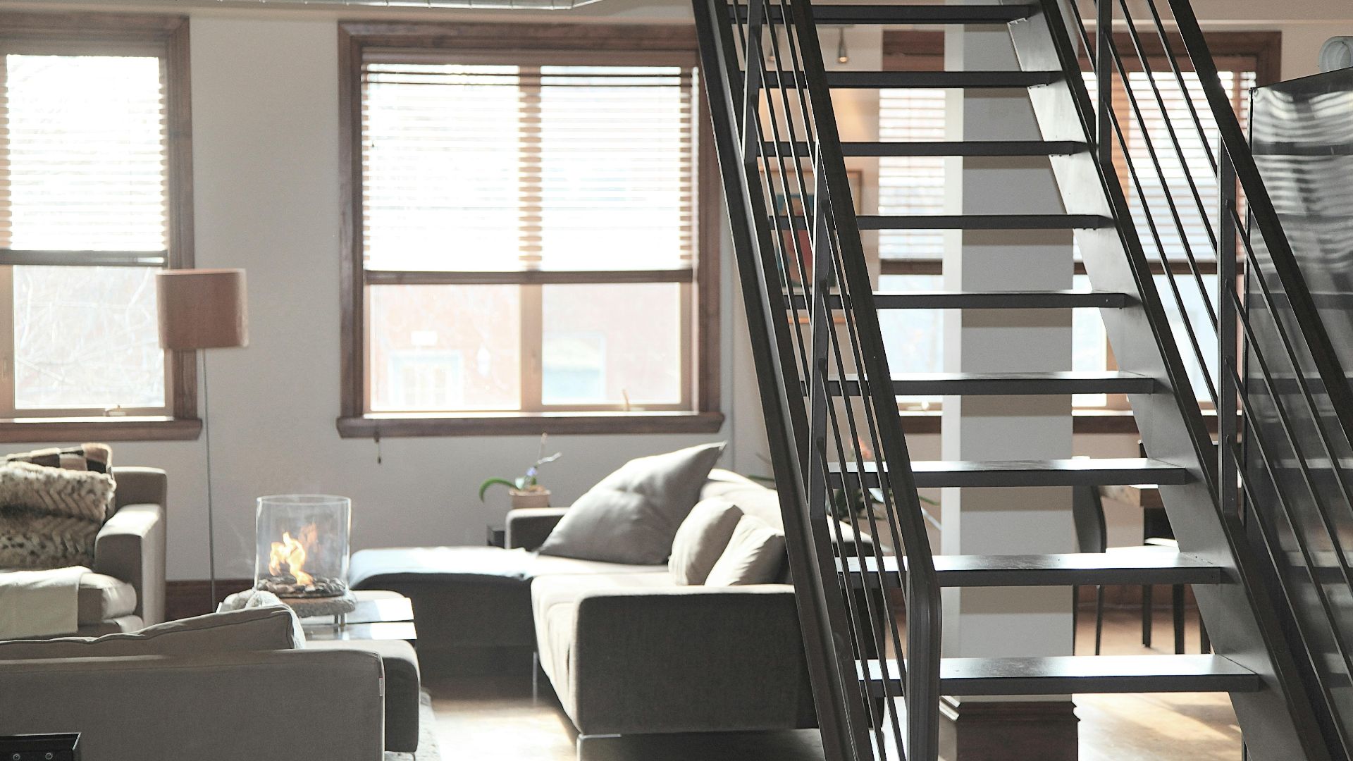Bright and modern loft interior featuring cozy furniture and industrial elements, perfect for urban living.