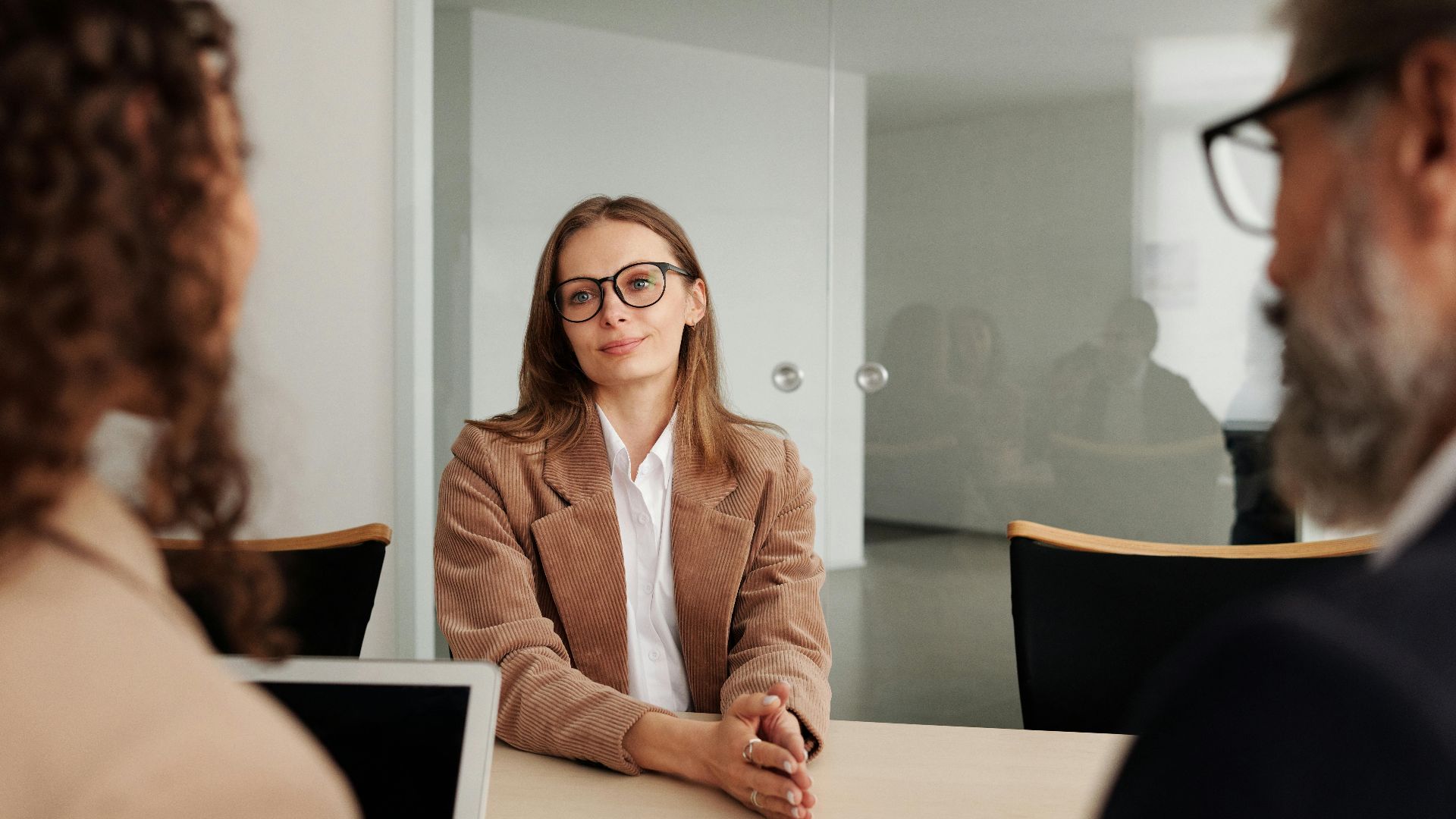 Young woman attending a job interview in a modern office, showcasing confidence and professionalism.