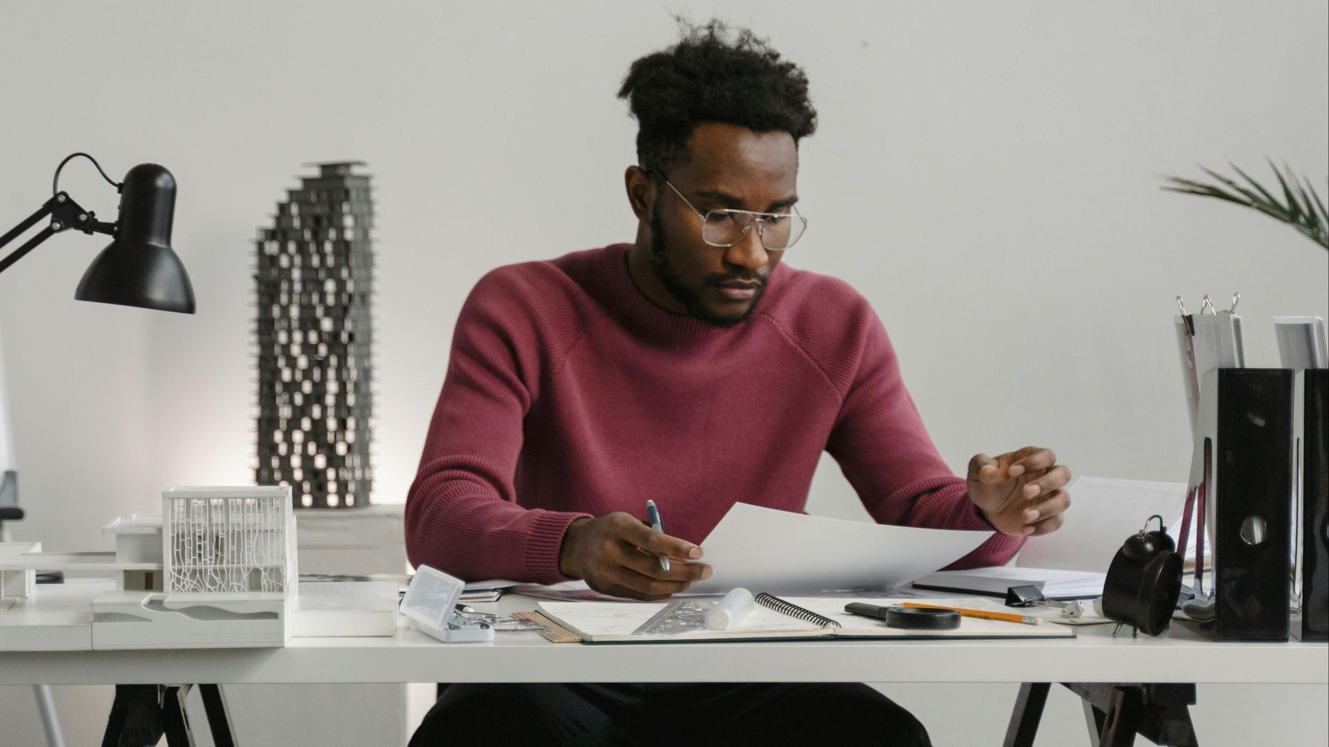 Man concentrating while reviewing documents at an office desk, signifying productivity and focus.