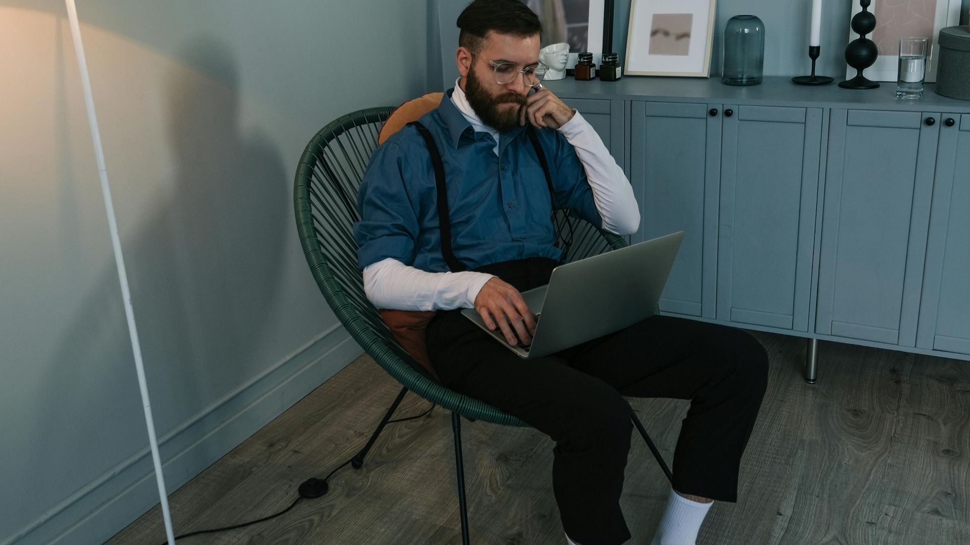 A man in a modern home office setting working on a laptop. Perfect for work from home concepts.