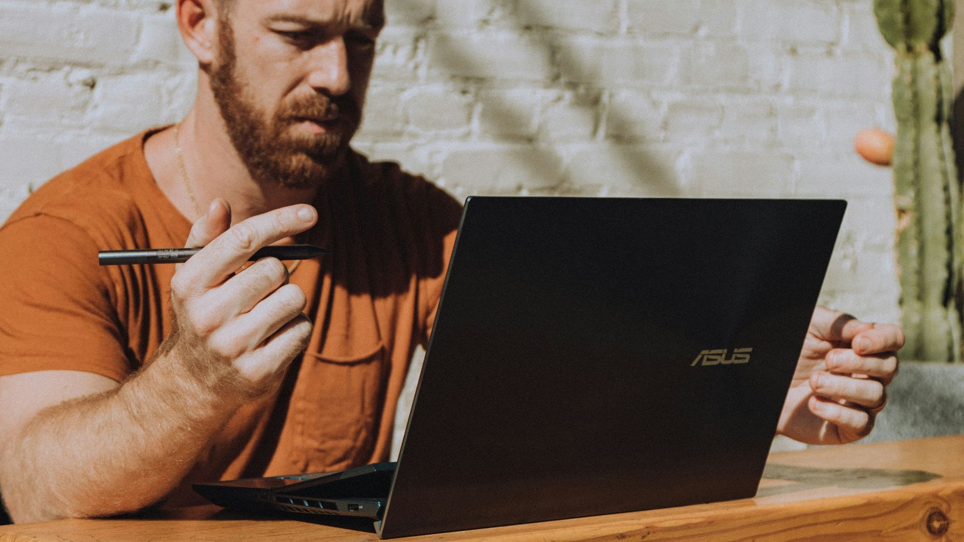 a man sitting at a table using a laptop computer