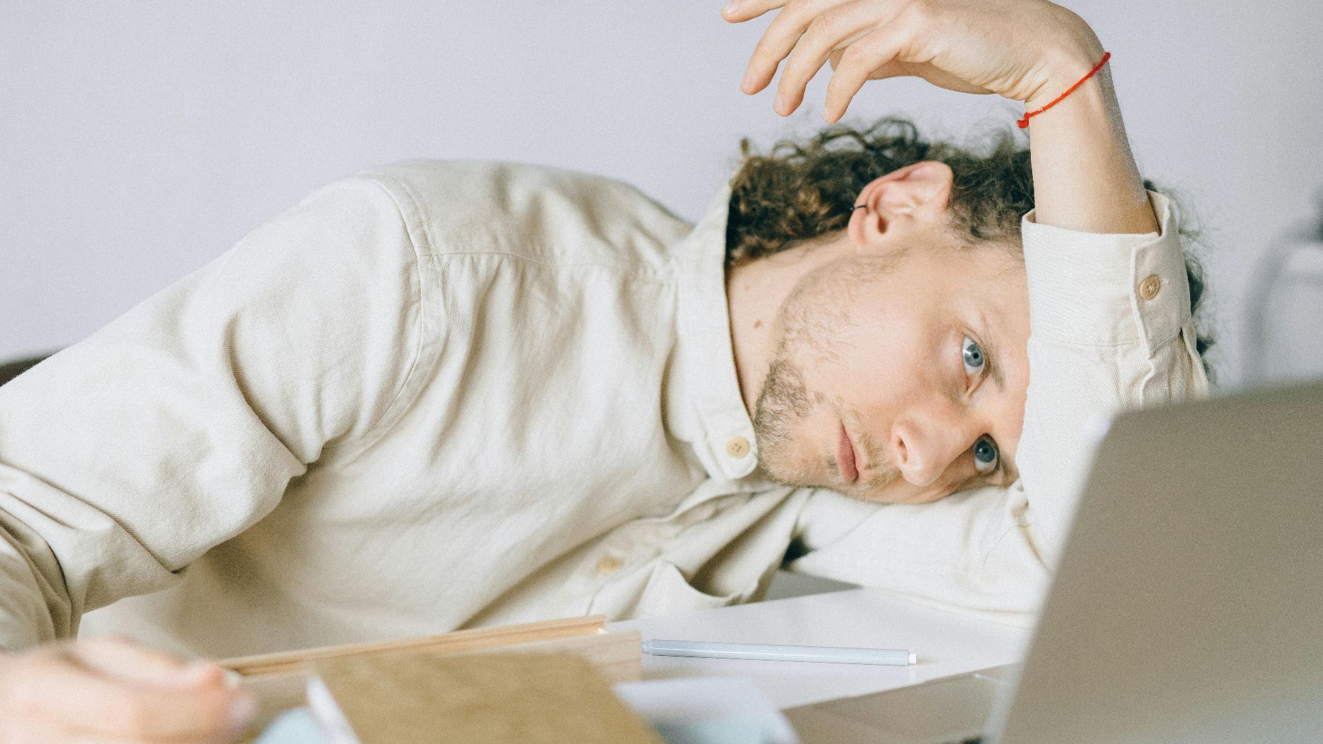 A tired Caucasian man at a desk, showing signs of exhaustion and stress, exemplifying workplace burnout.