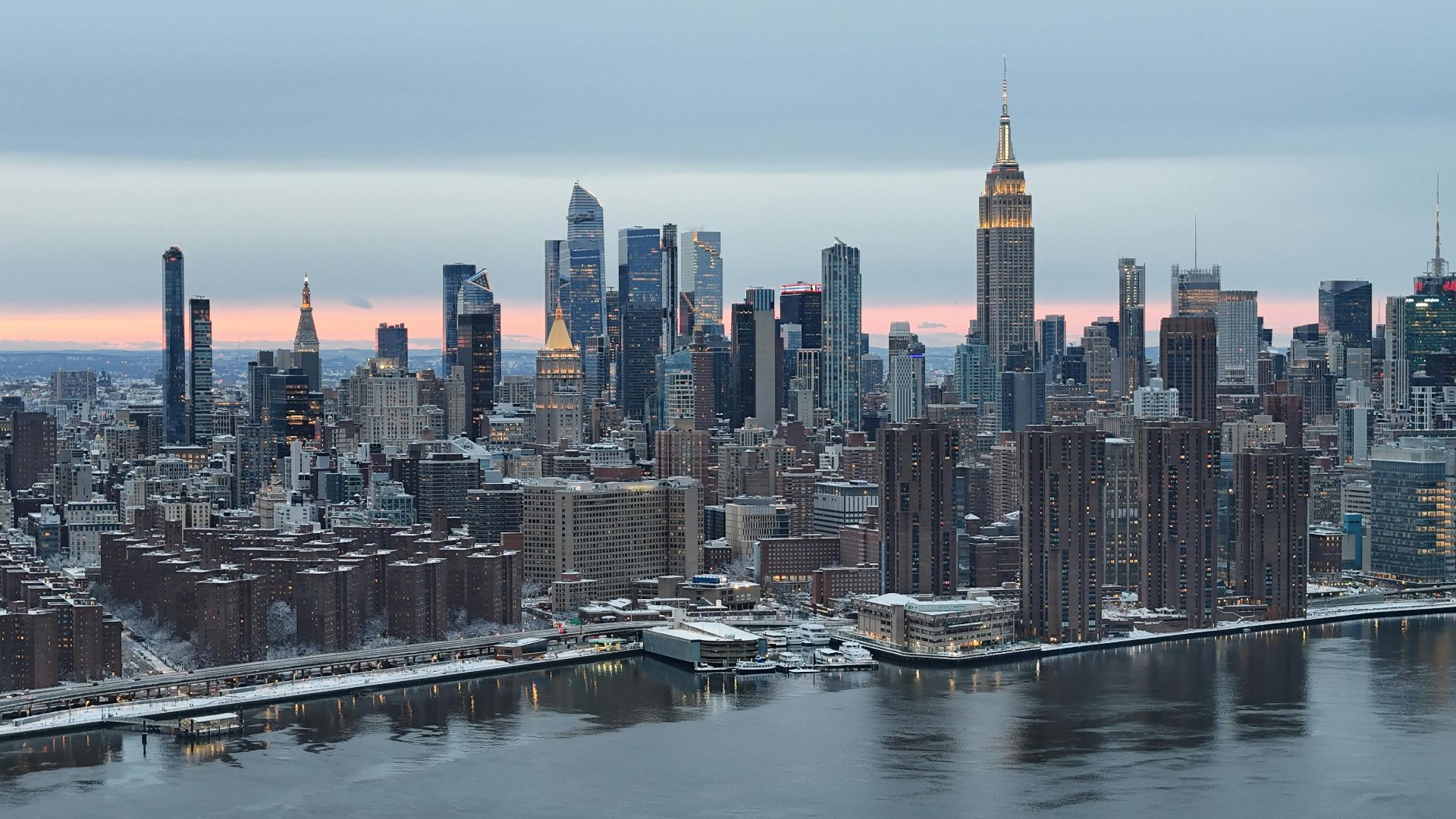 Stunning aerial view of Manhattan skyline during winter sunset, showcasing the iconic Empire State Building.