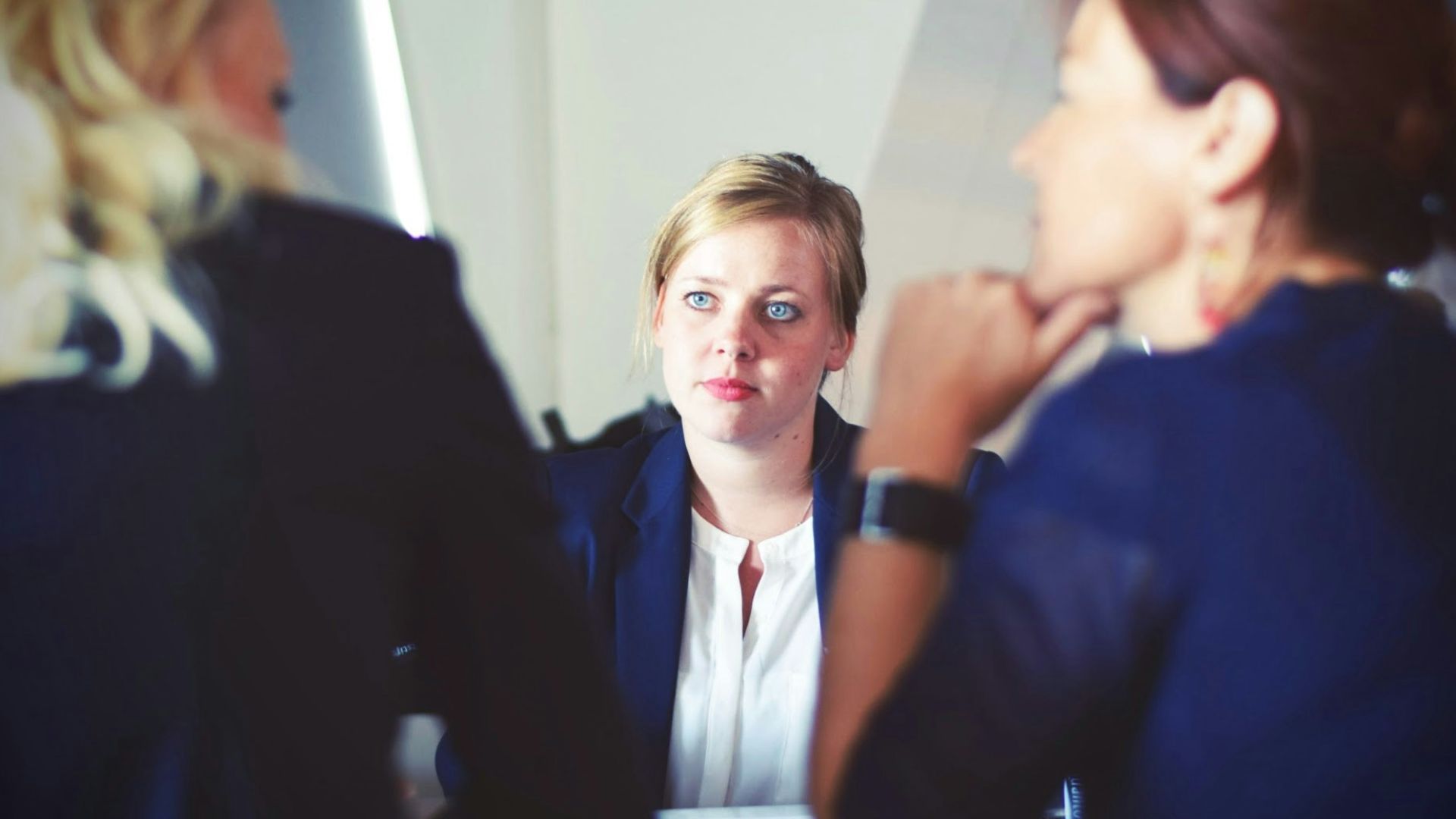 three women sitting beside table
