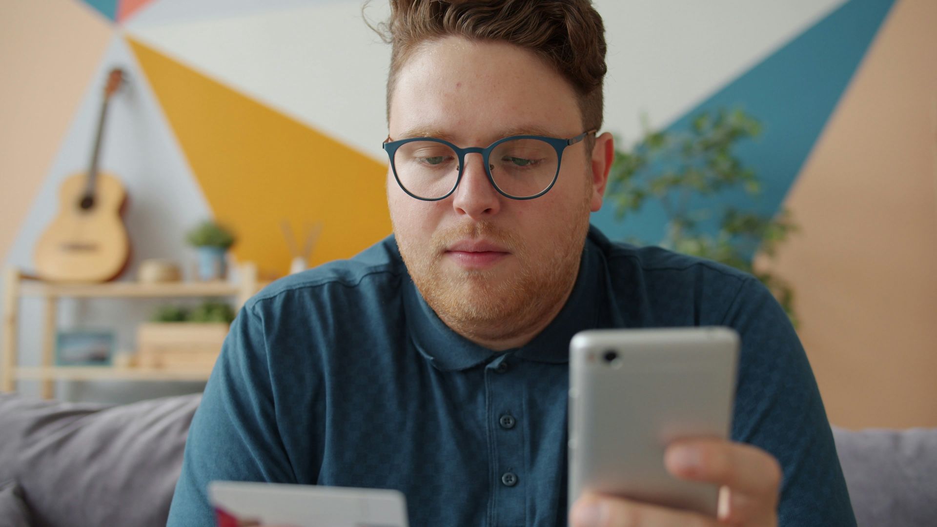 Man holding credit card and smartphone for online shopping.