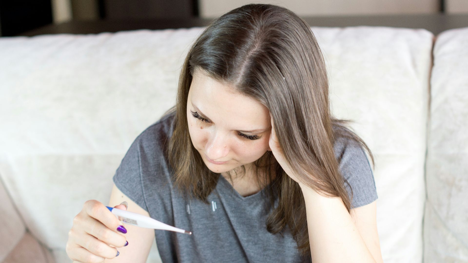 a woman sitting on a couch holding a pen and paper