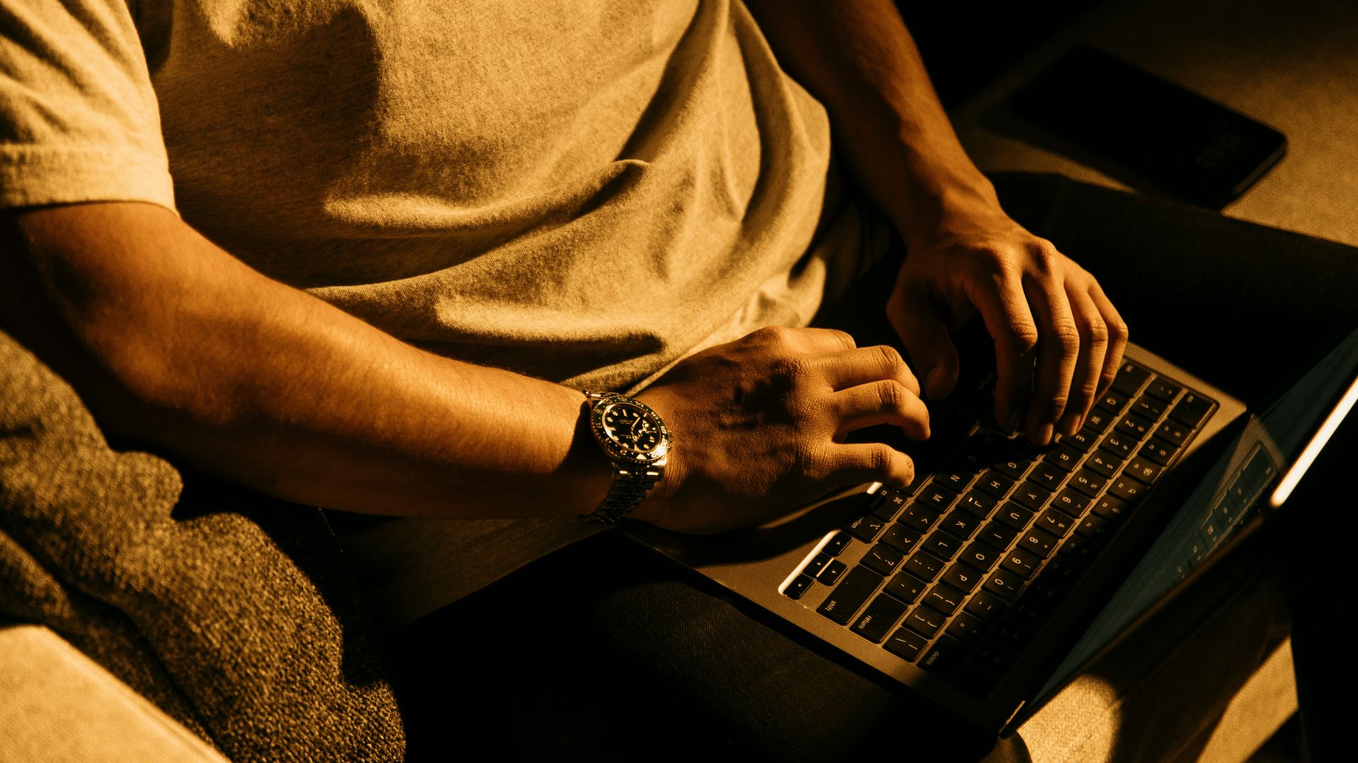 a man sitting on a couch using a laptop computer