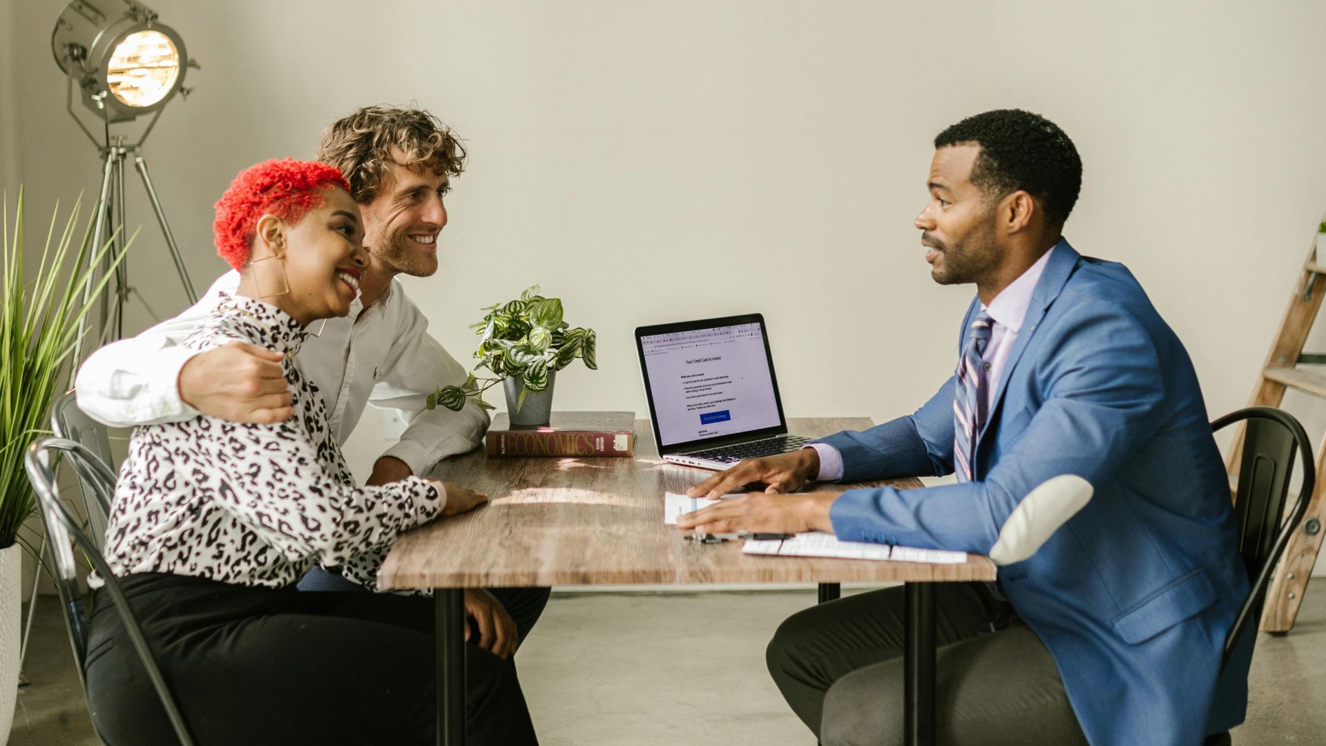 A professional financial advisor discusses options with a couple in a modern office setting.