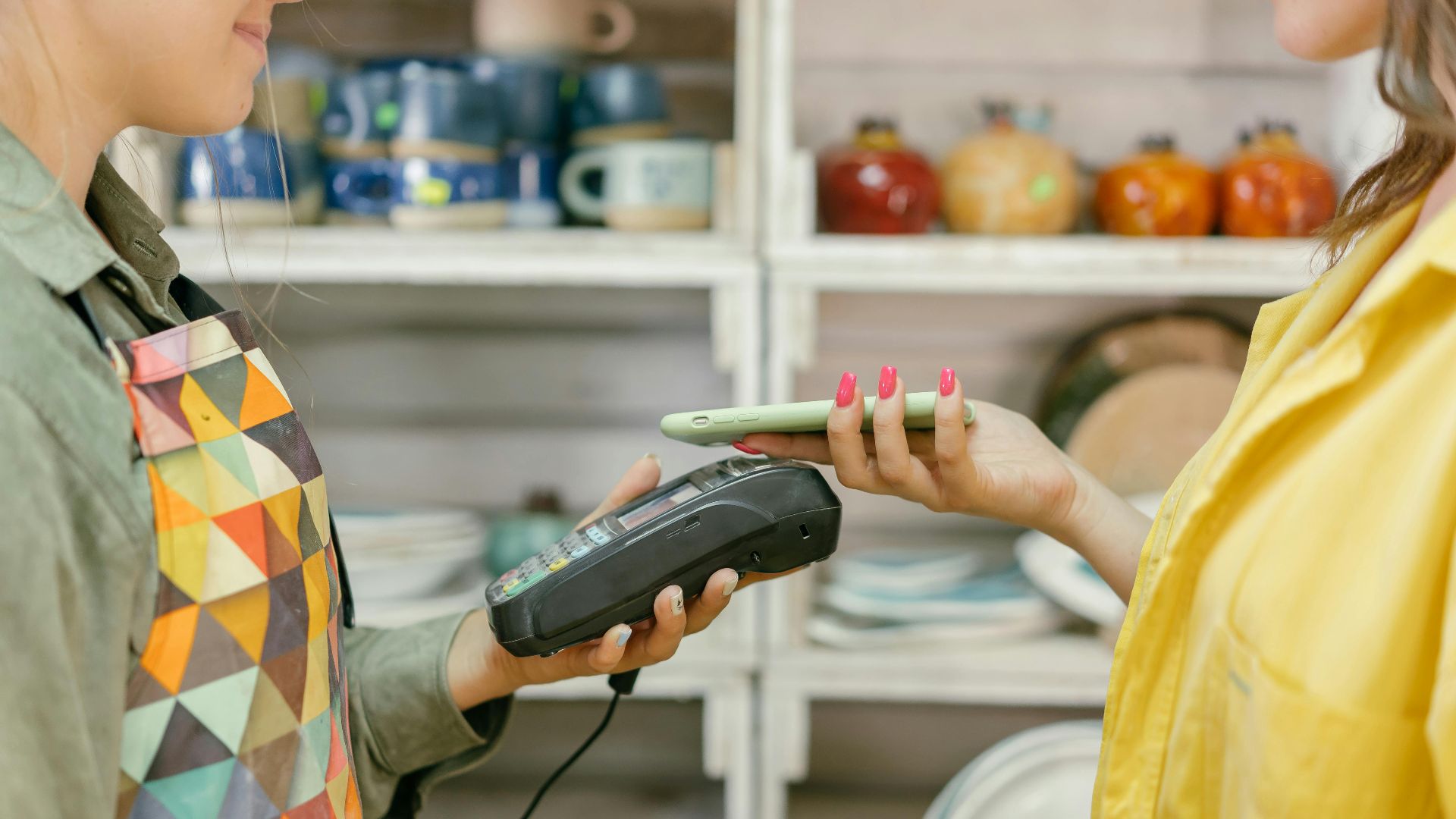 A customer makes a cashless payment using a smartphone in a retail store. Modern technology meets convenience.