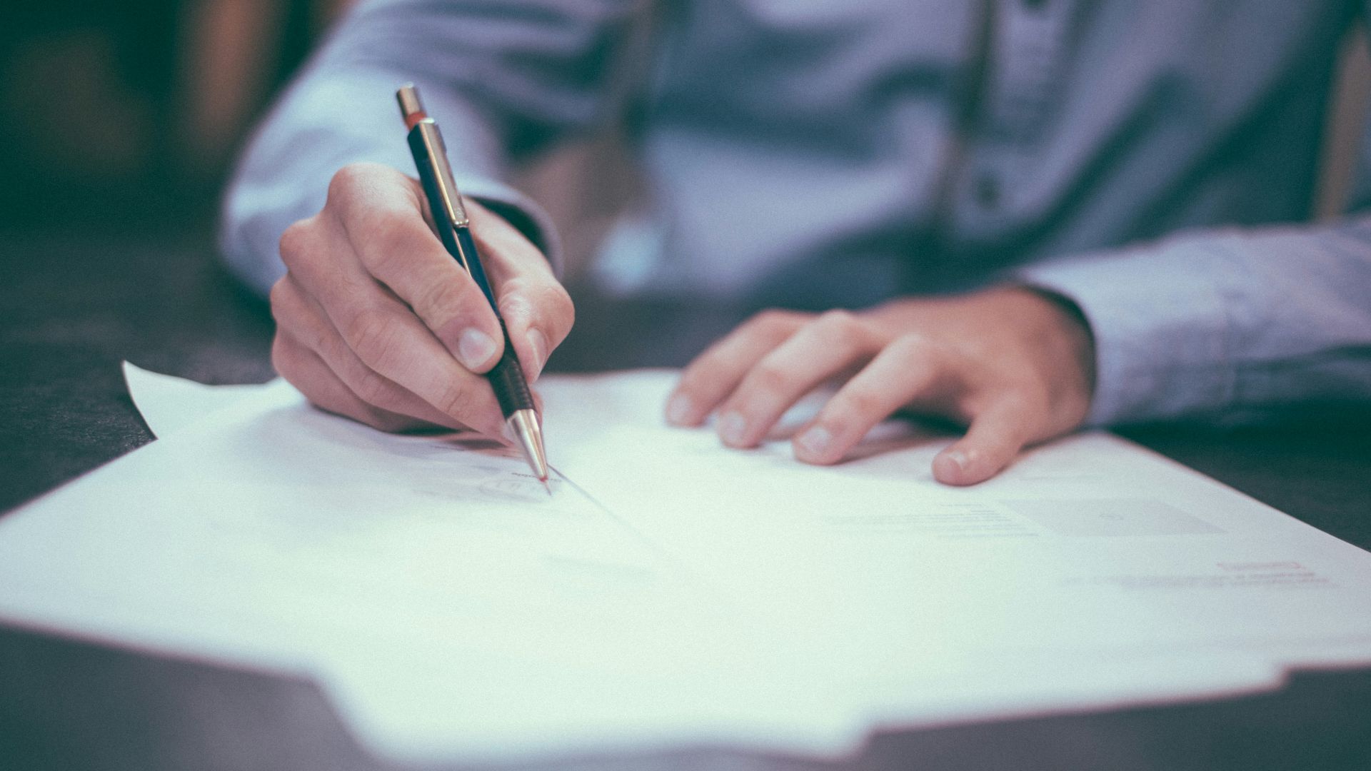 man writing on paper