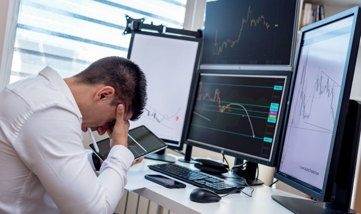 Man with Headache in Front of the Computer and Holding a Tablet