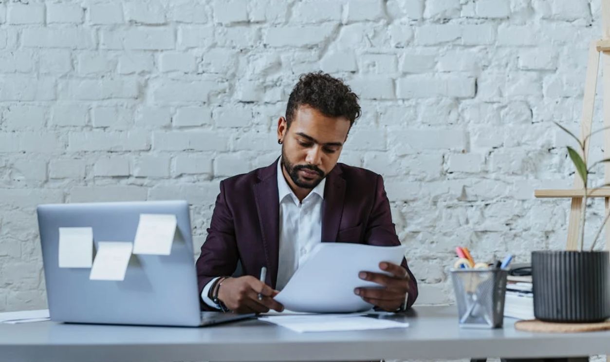 Man in Black Suit Looking the Document