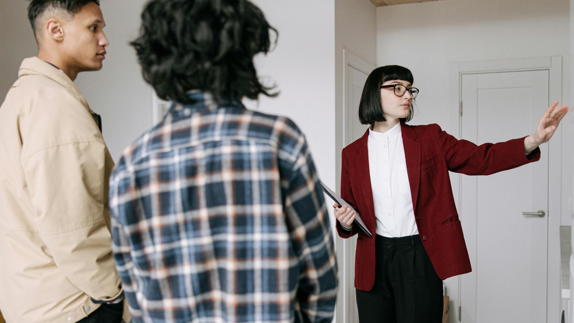 Real estate agent presenting an apartment to potential buyers during a property tour.