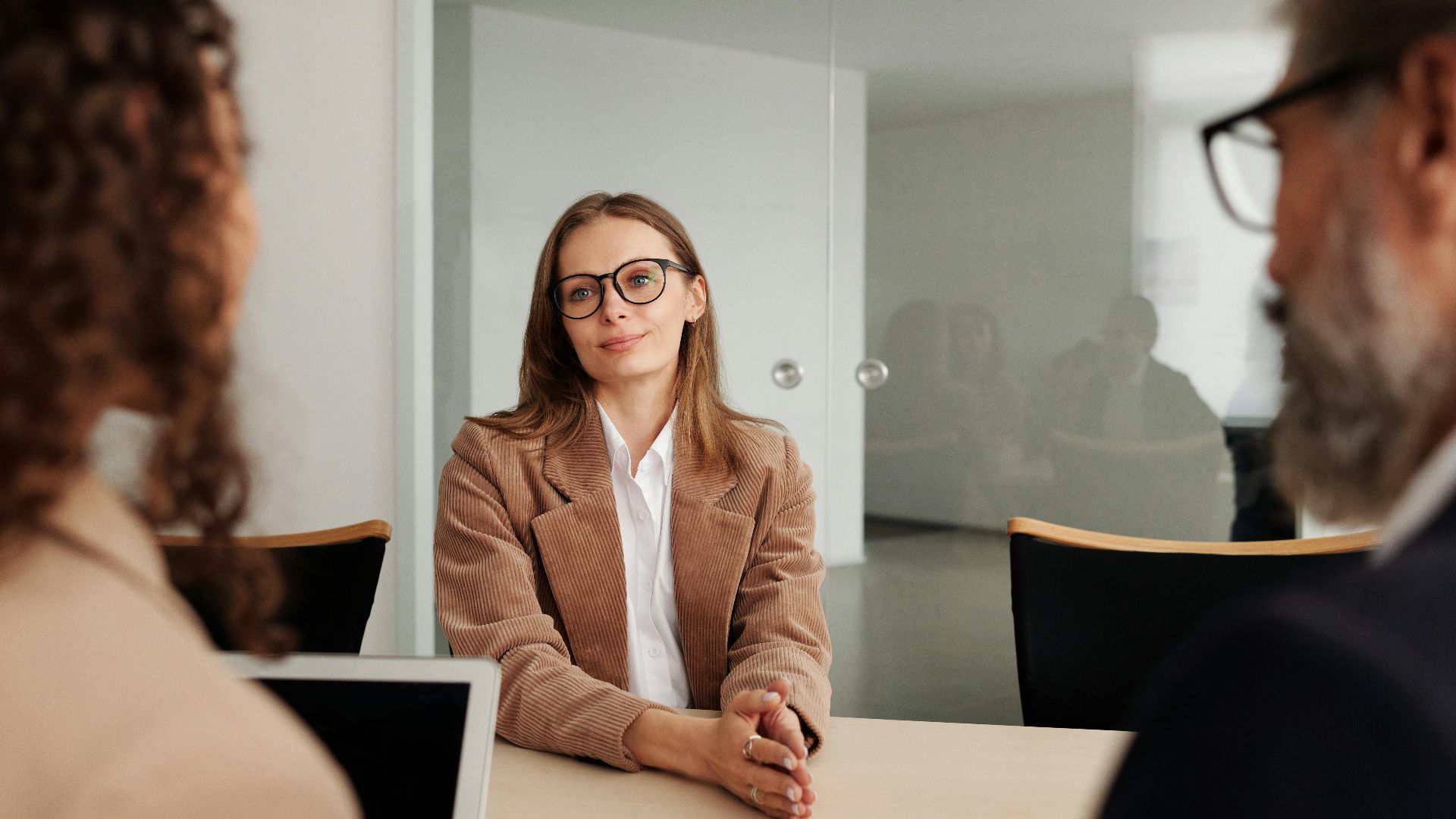 Young woman attending a job interview in a modern office, showcasing confidence and professionalism.