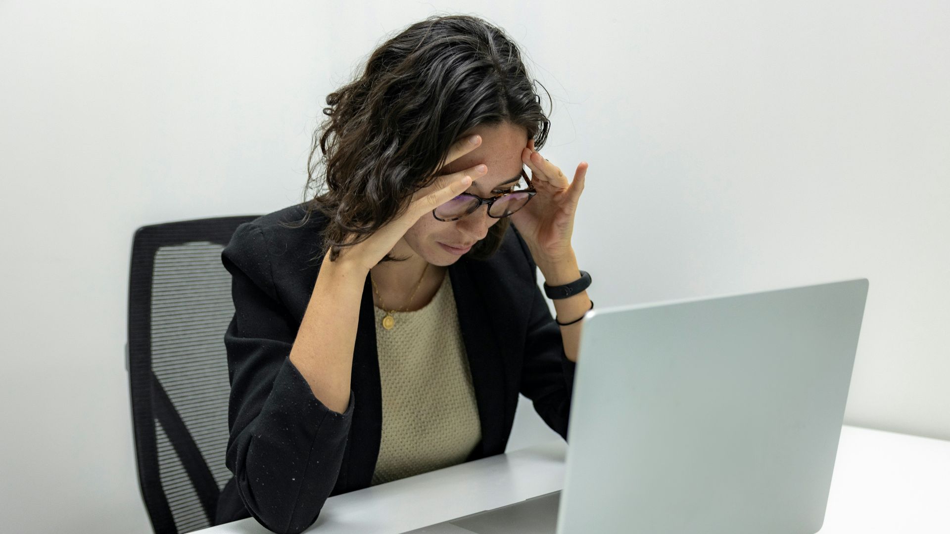 a woman sitting in front of a laptop computer