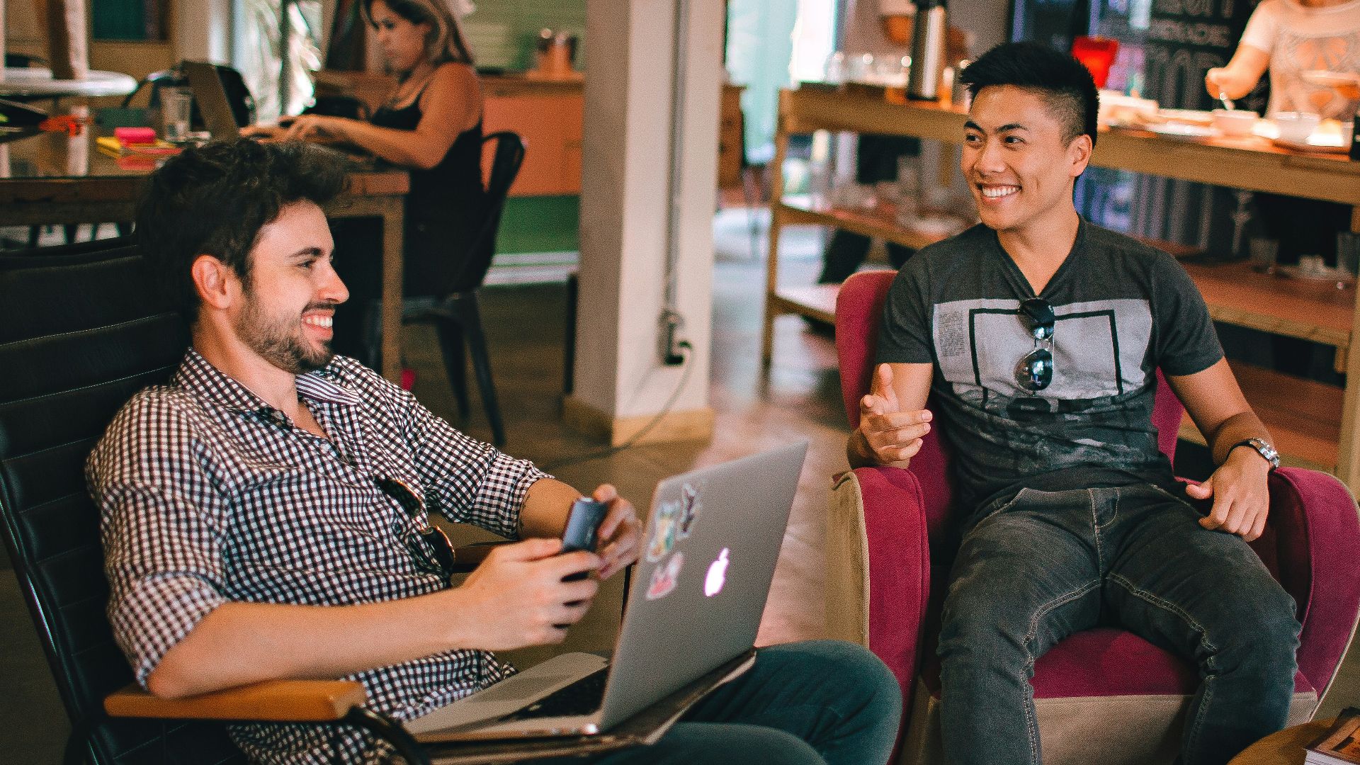 two men laughing white sitting on chairs