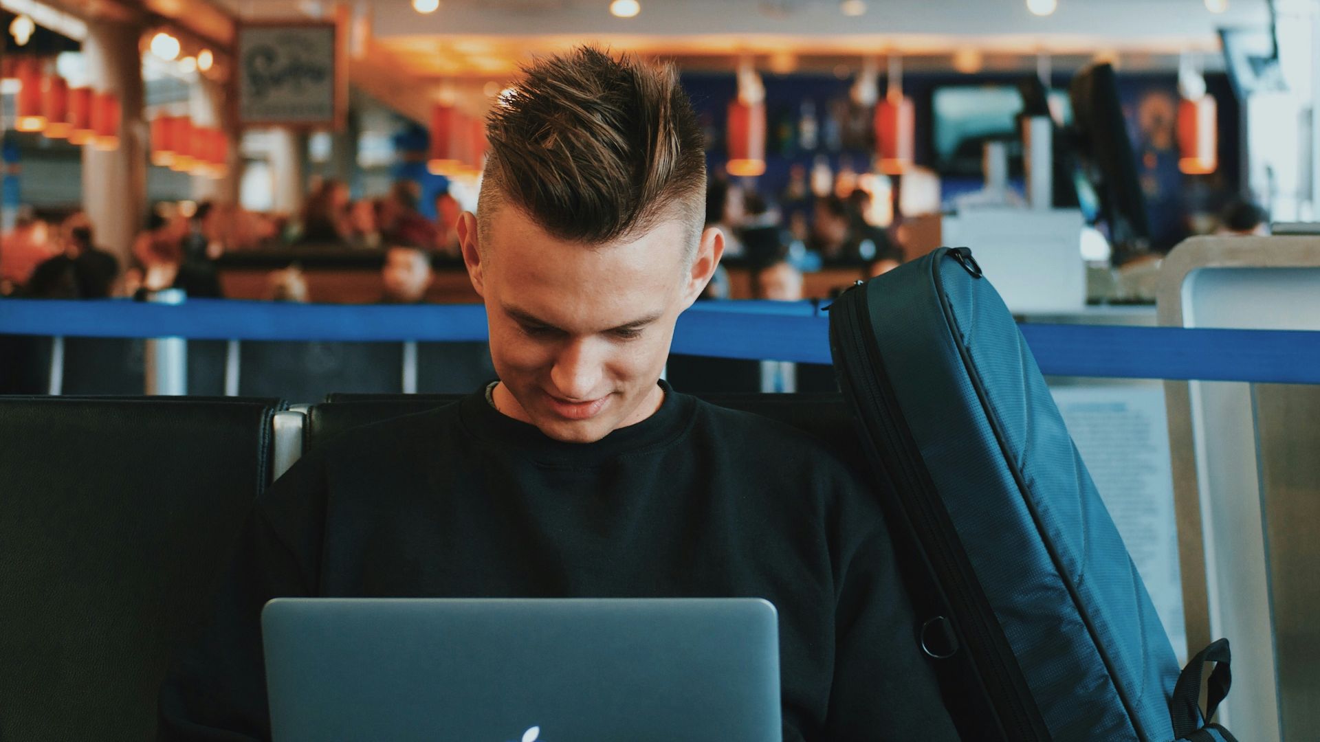 smiling man facing Apple MacBook