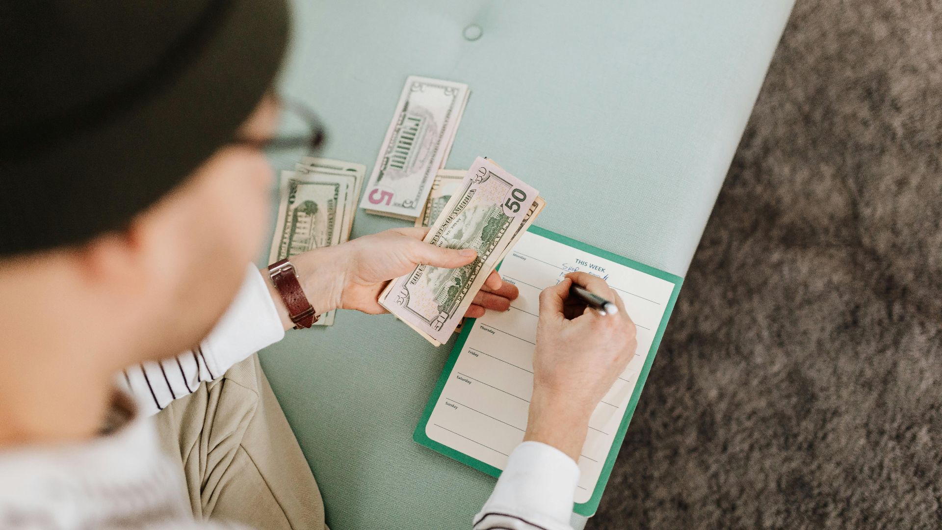 Individual budgeting with US dollars and a planner, focusing on financial planning.