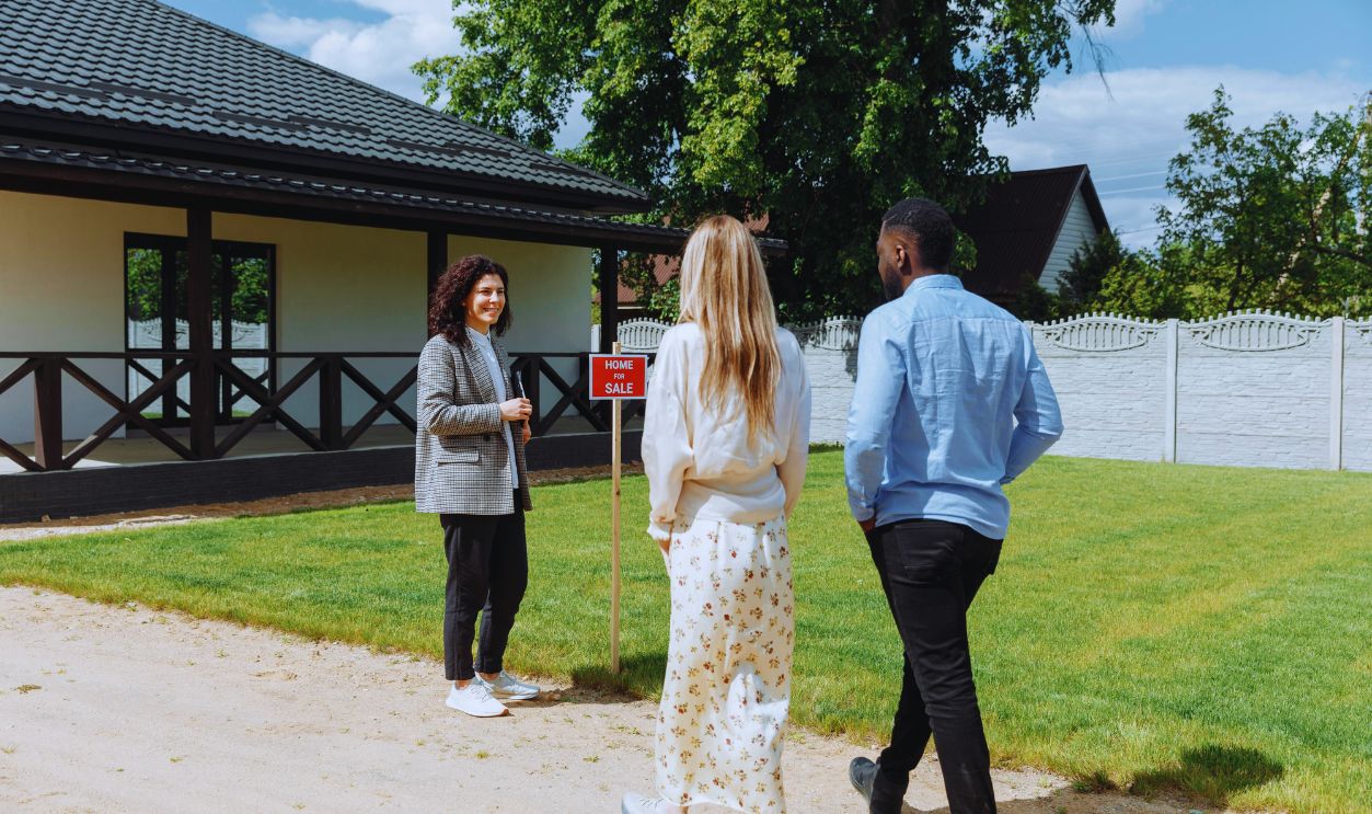 A Couple Walking Towards the Woman Standing Beside a Wooden Post
