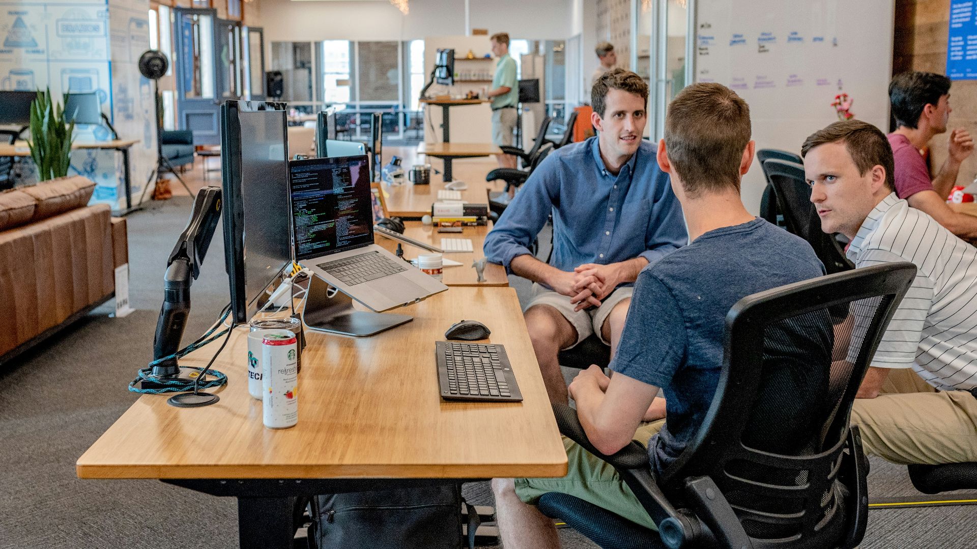 three men sitting on chair beside tables