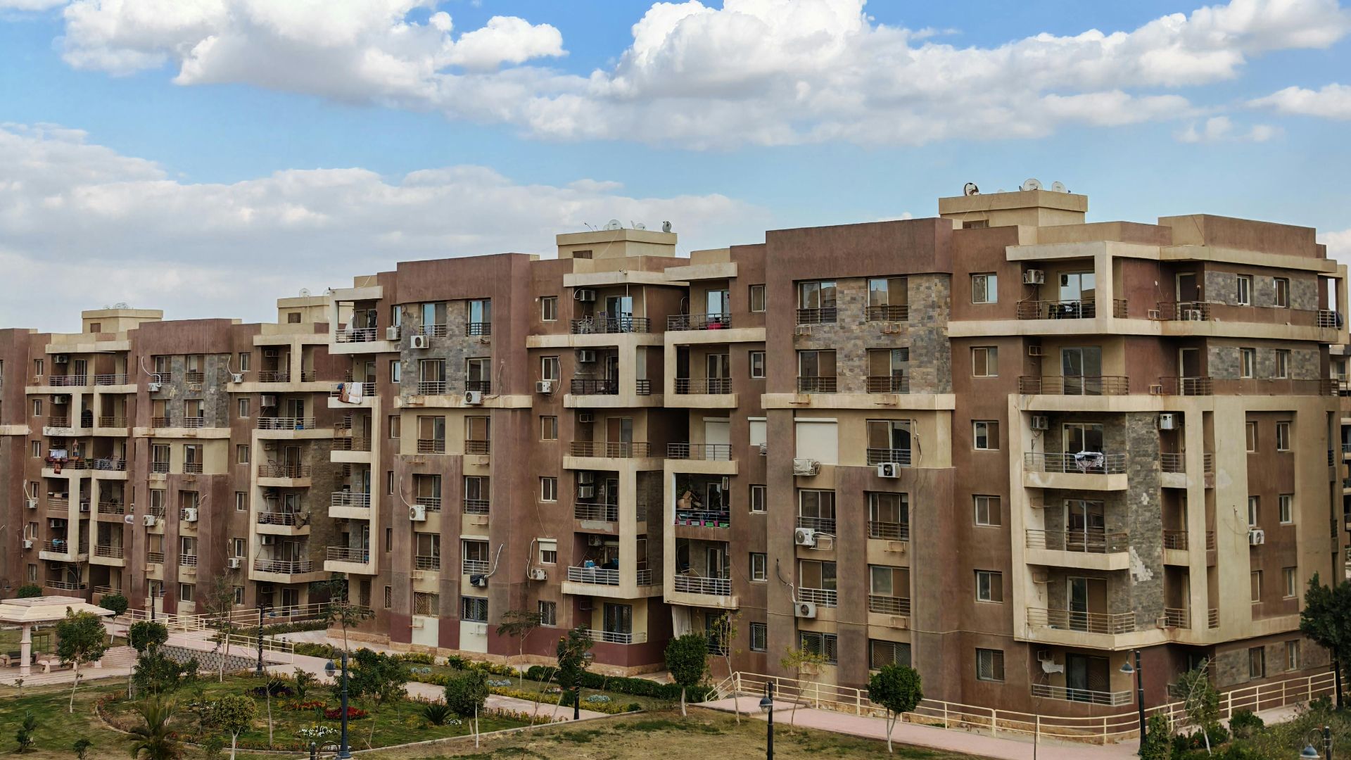 Exterior view of a modern residential apartment building under a clear blue sky.