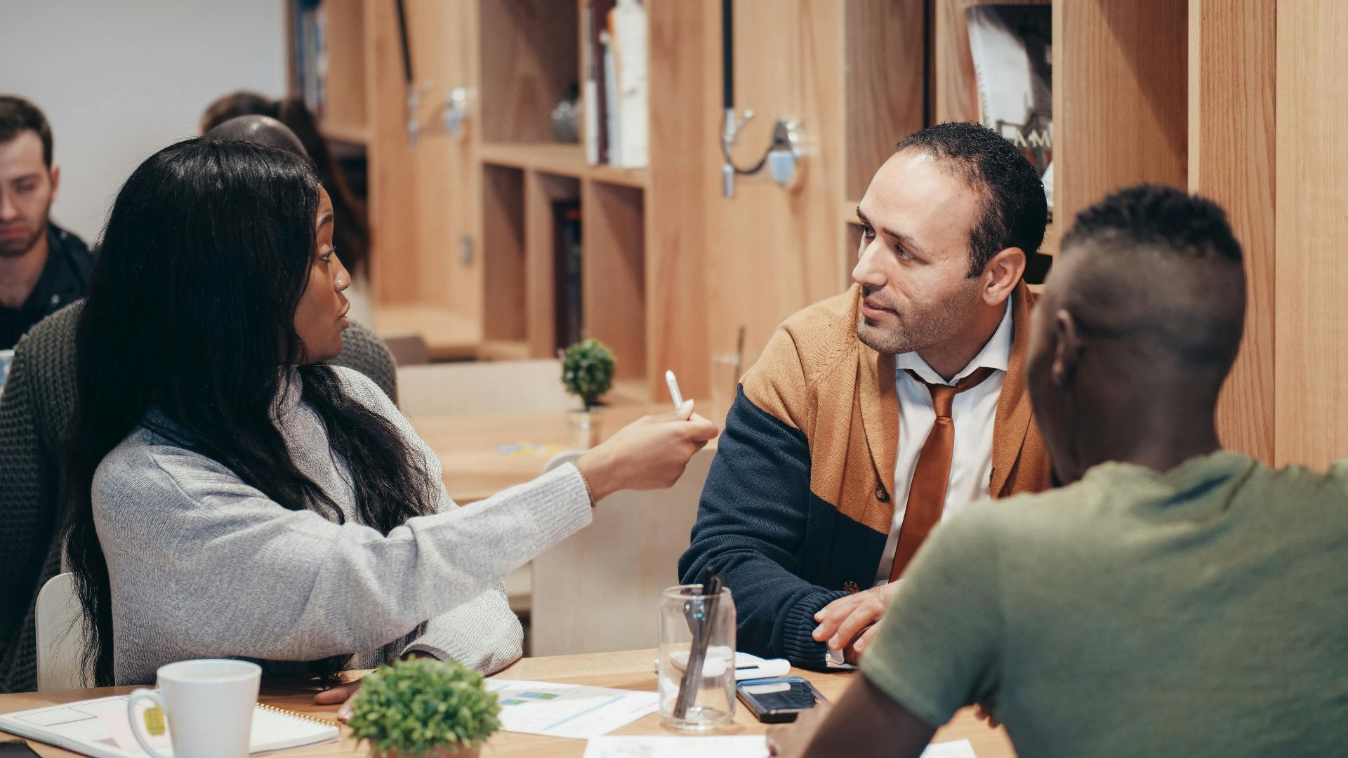 A diverse group of professionals discussing ideas in a collaborative workspace.