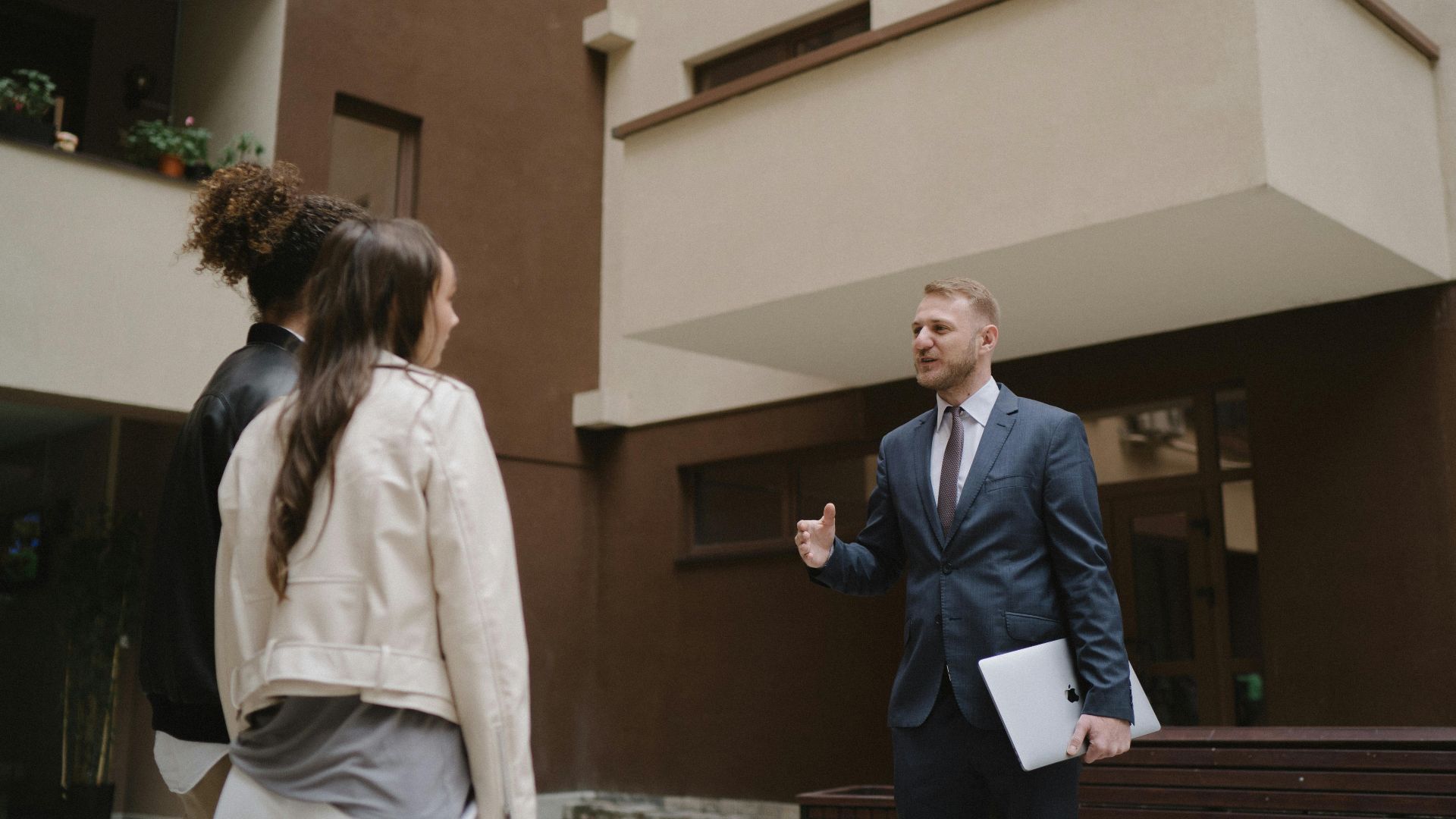A real estate agent shows an apartment to a couple, illustrating a property tour experience.