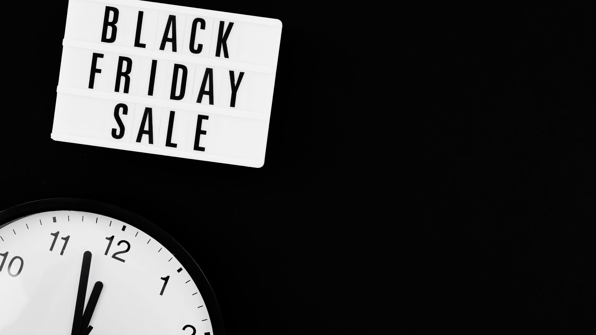 Minimalist Black Friday sale sign with clock on black background for promotions.
