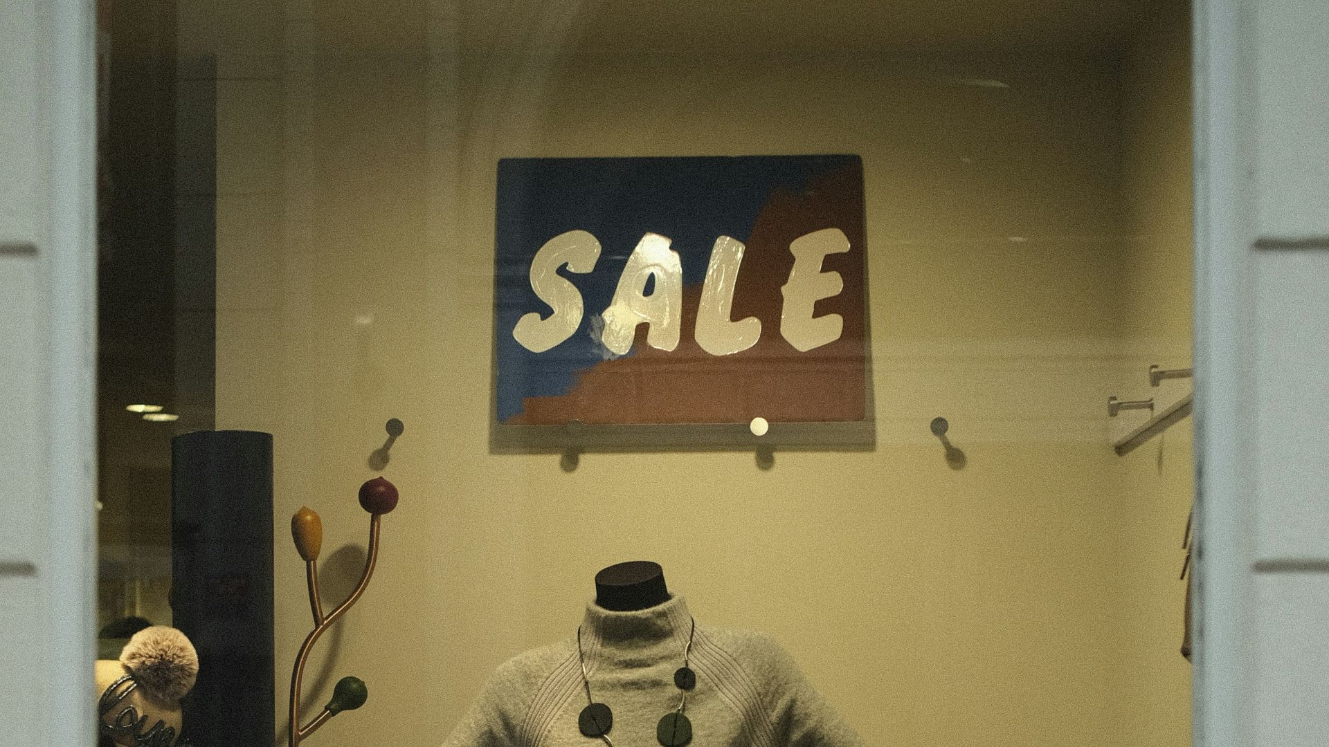 Mannequin in store window with sale sign
