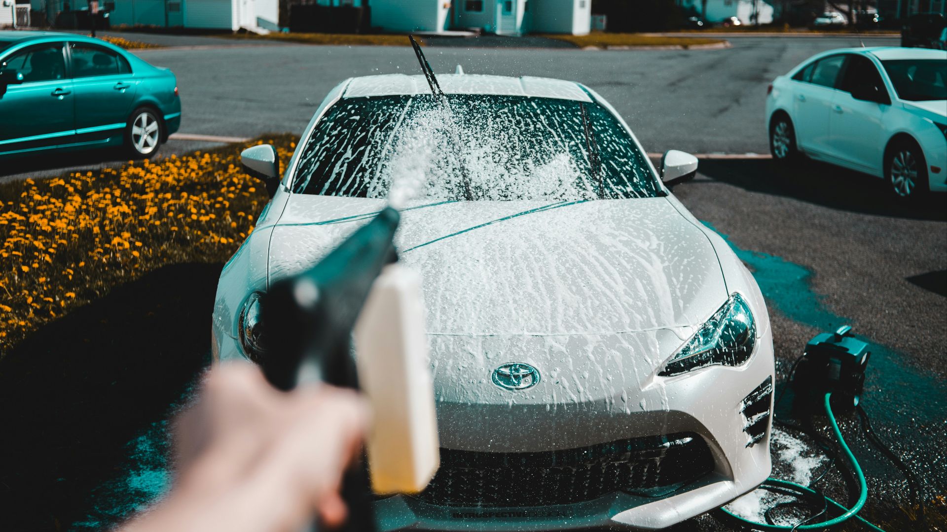 person spraying water on vehicle