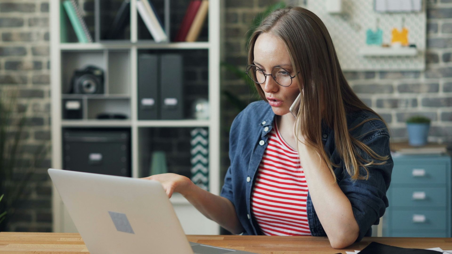 a woman sitting at a table using a laptop computer