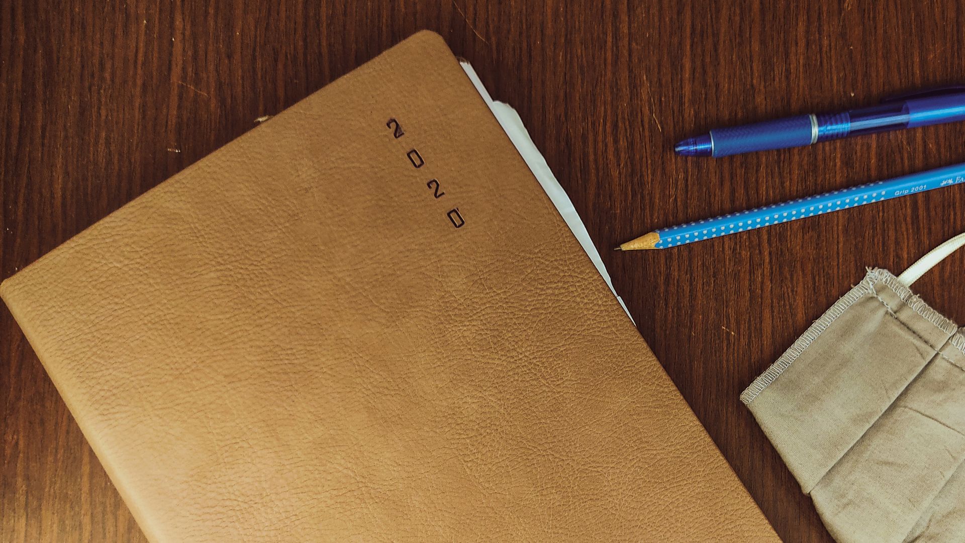 brown paper bag beside blue and white click pen