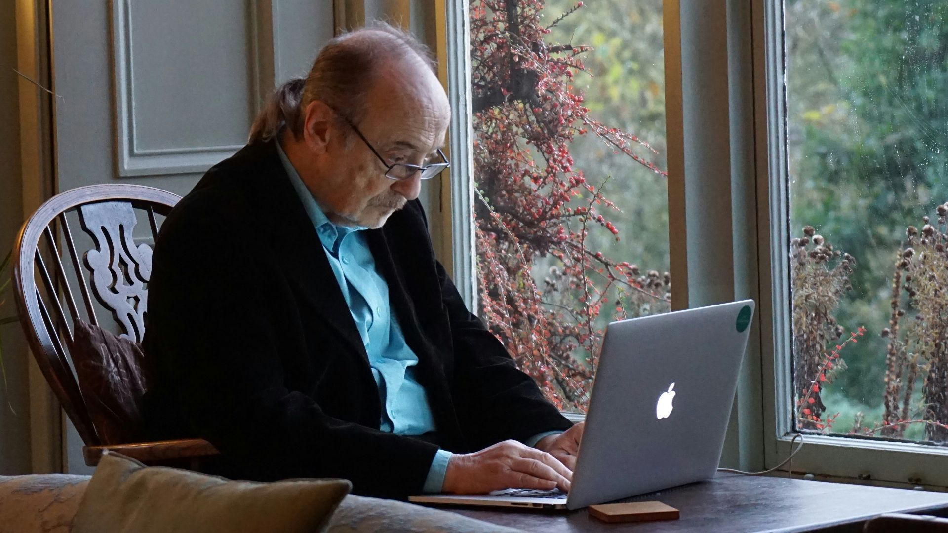 man in black suit jacket using macbook