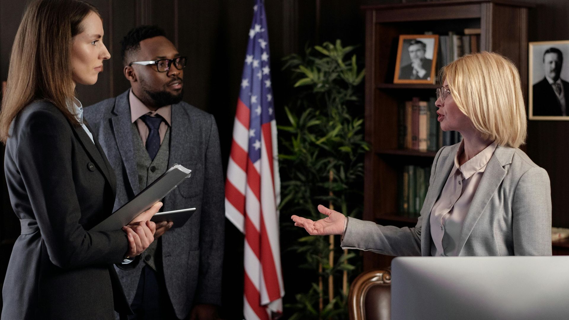Diverse group of business professionals engaging in a discussion in a modern office setting.