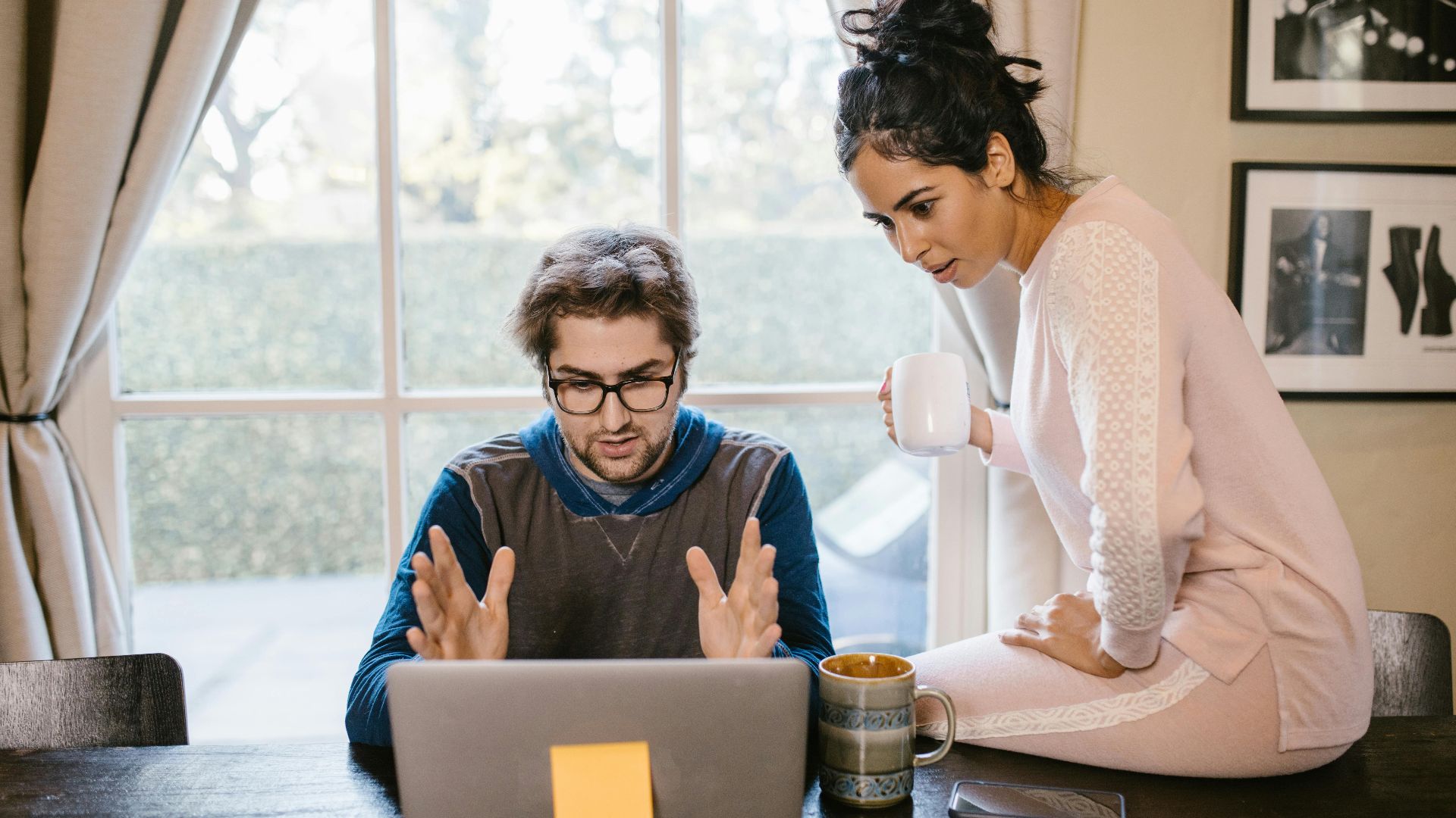 A man and woman working together on a laptop at a wooden table with warm, relaxing ambiance.