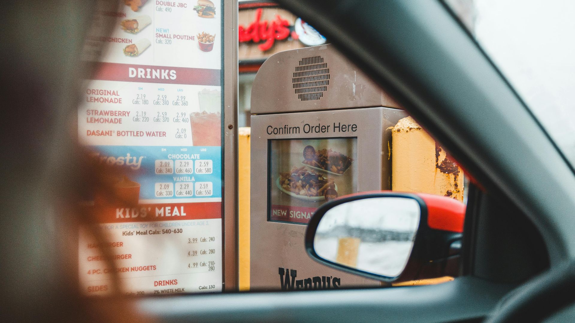 A customer interacts with a drive-thru menu to order fast food conveniently from their car.
