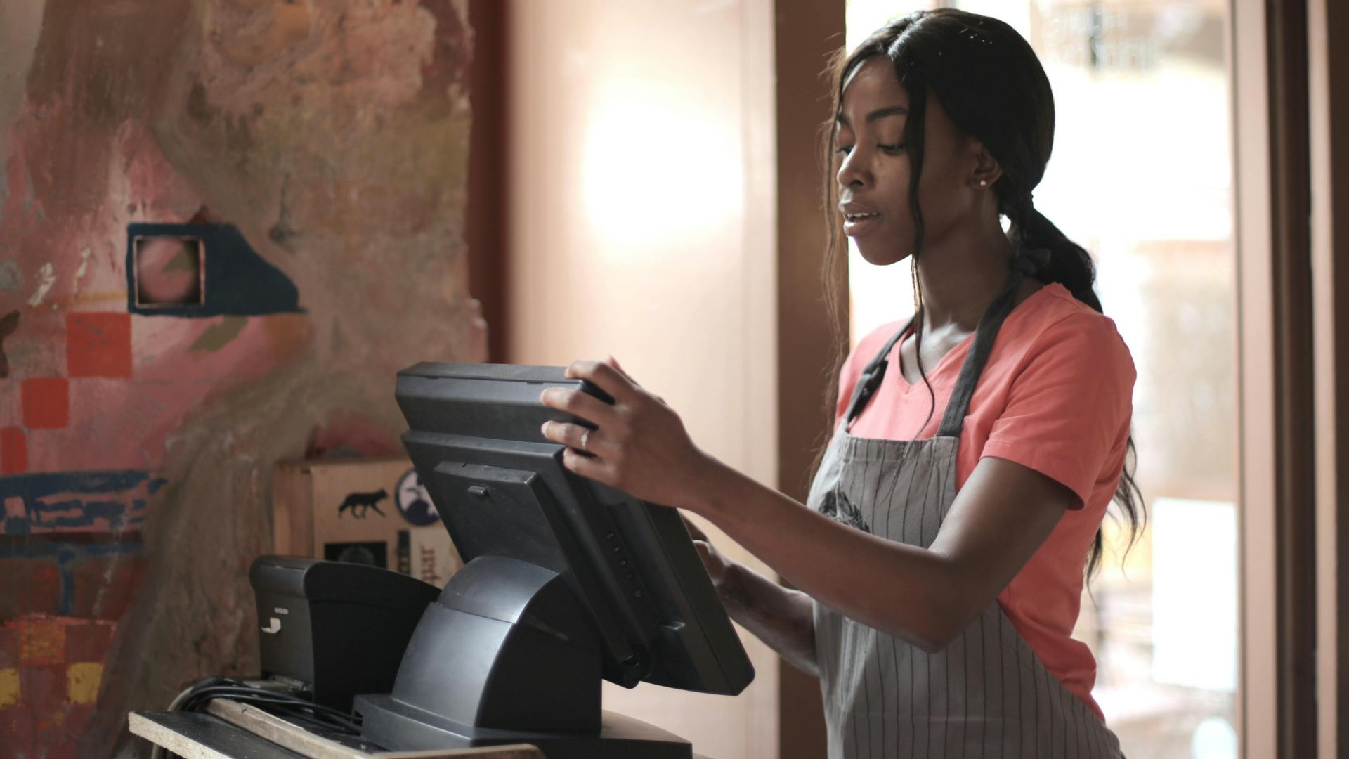 A diligent cashier processes sales in a charming store environment, enhancing customer service.